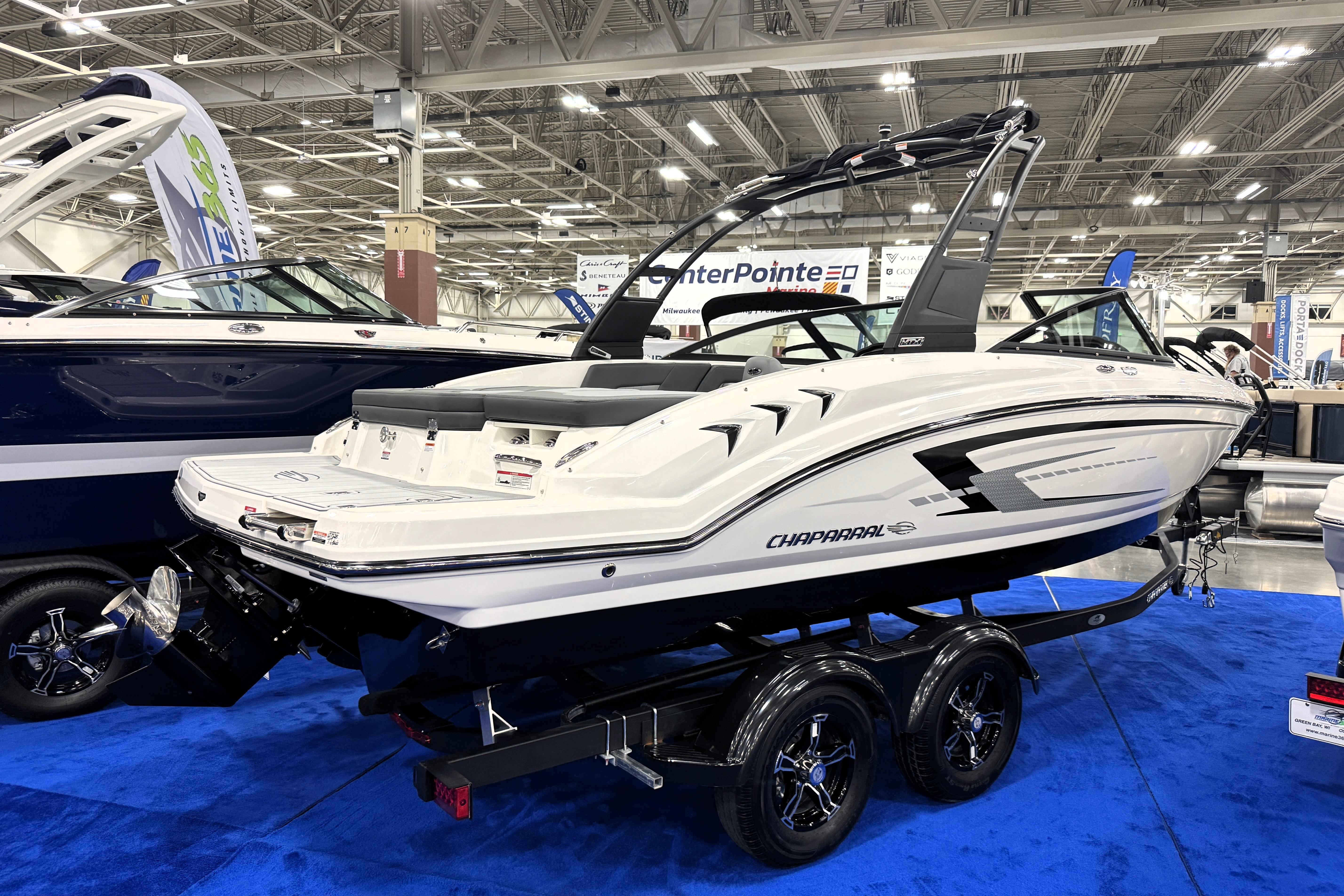 2026 Chaparral 23 SSi boat displayed indoors on a blue carpet.
