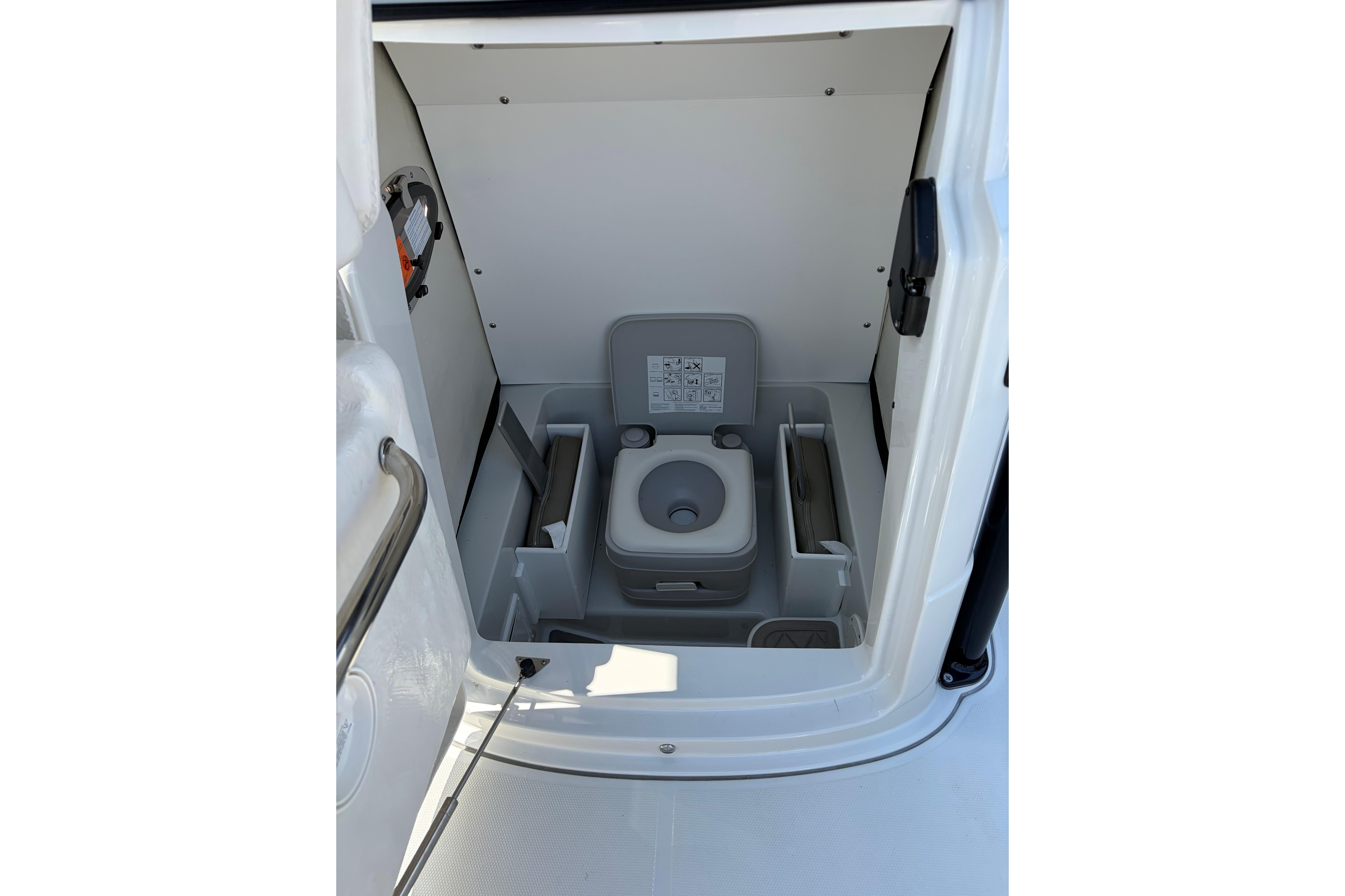 Portable toilet inside 2026 Crownline 210 CC Finseeker boat cabin.