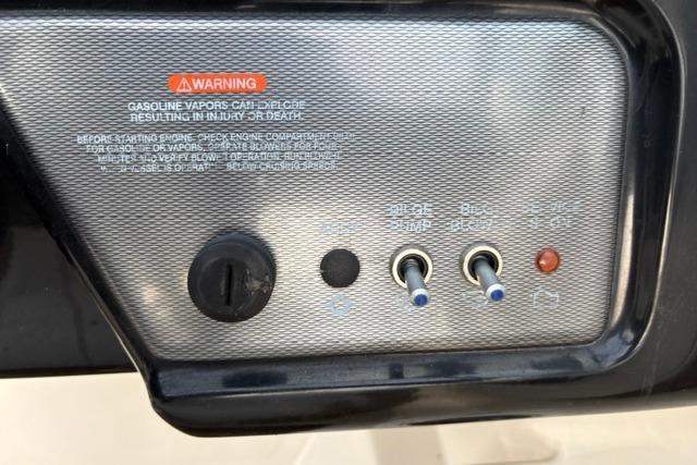 Control panel of a 2017 Searay SPX210 boat with warning label and switches.