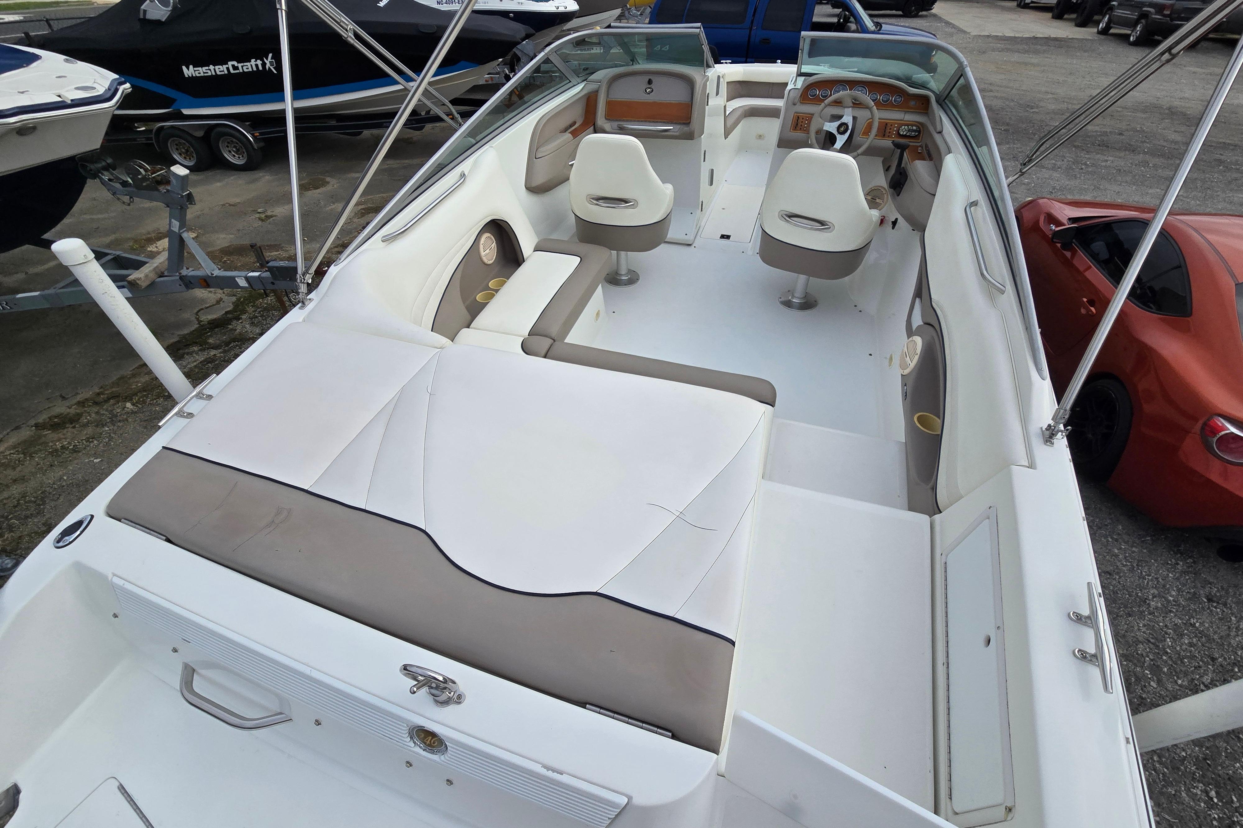 2000 Cobalt 246 boat interior with white seating and dashboard, parked near other vehicles.