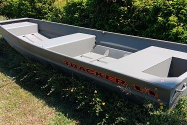 2026 Tracker Grizzly 14 Jon boat in grassy area, showcasing sleek design and durable build.