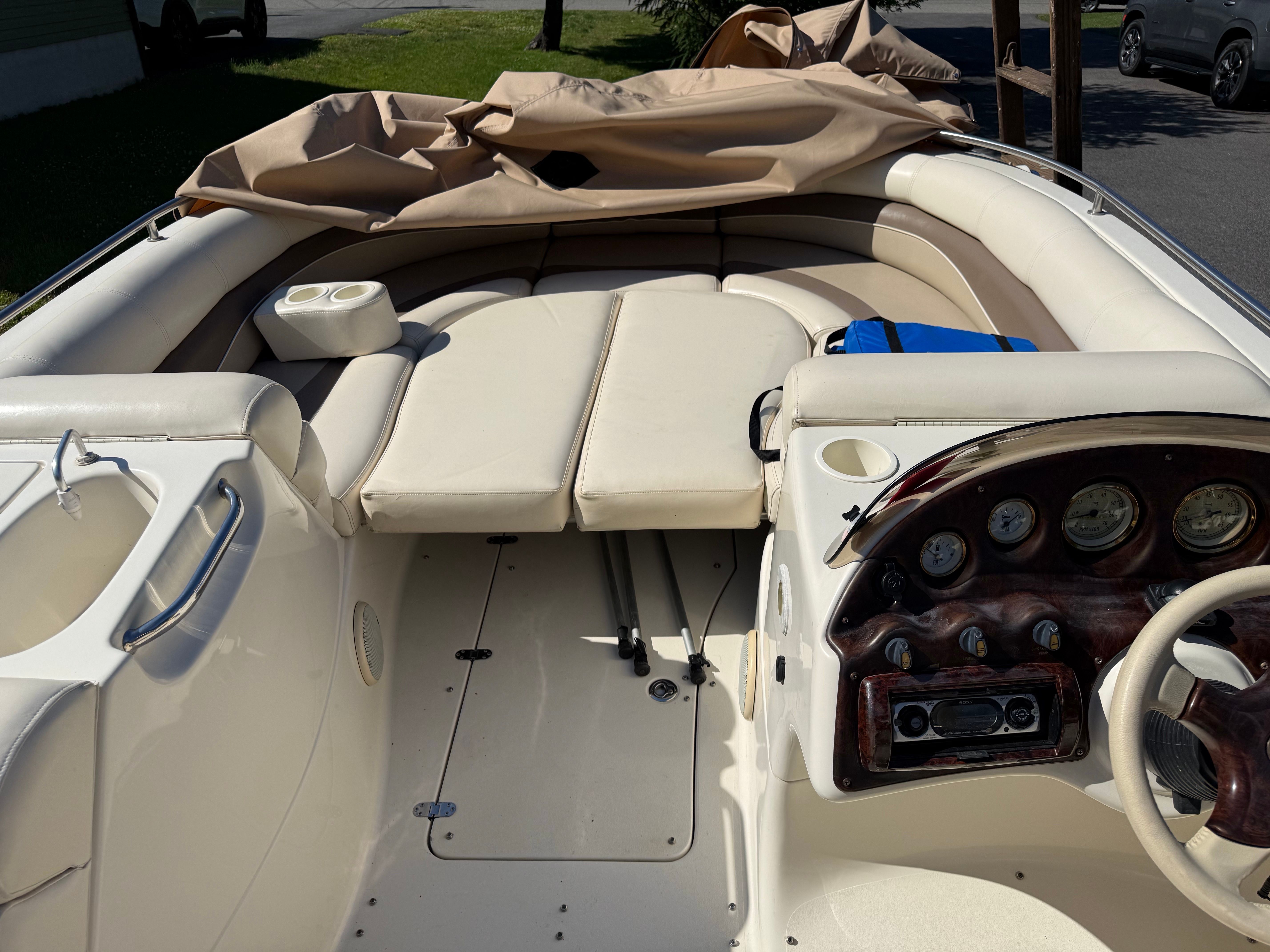 The image shows the cockpit of a Bennington RL210 boat with beige seating and a helm.