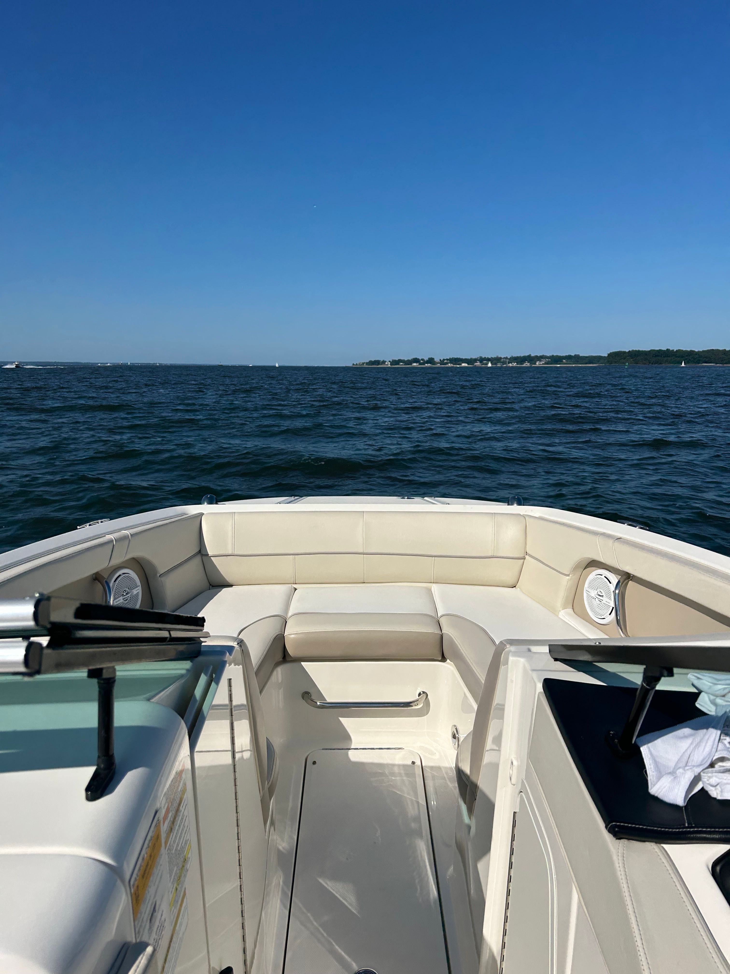 The image shows the deck of a Sea Ray 220 Sundeck boat on the water.