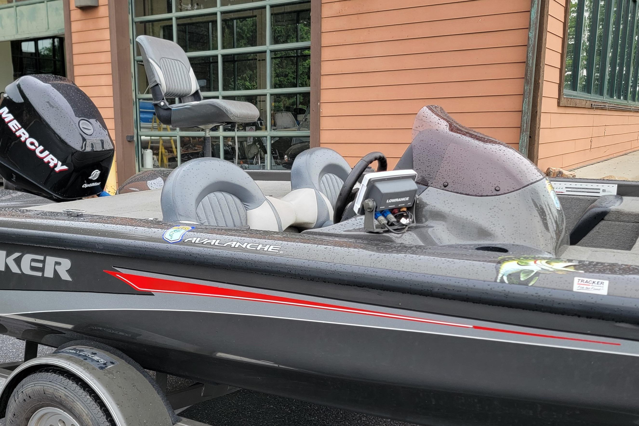 2006 Tracker Avalanche 18 SC boat with Mercury engine, parked near a building.