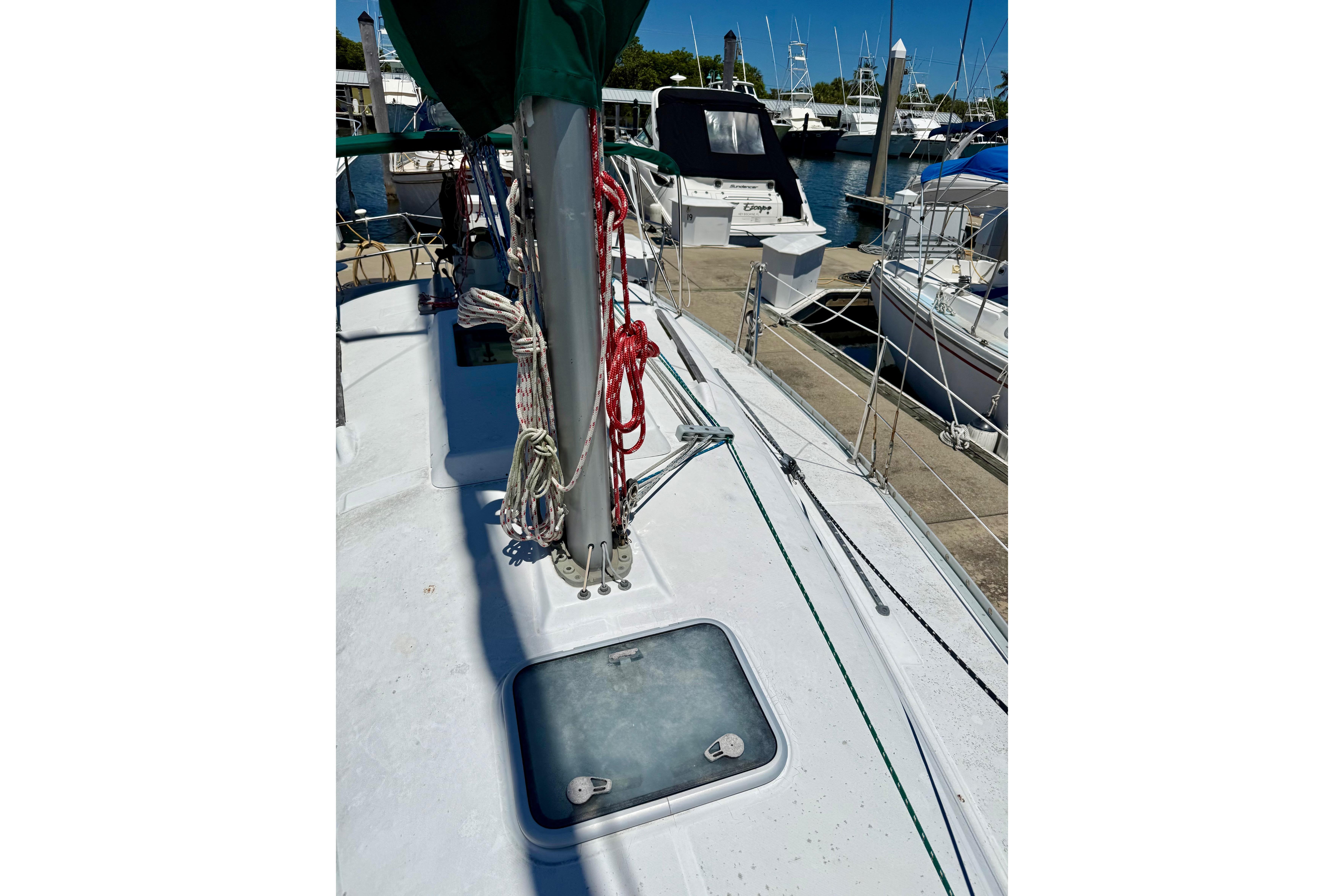 2002 Beneteau Oceanis Clipper 311 sailboat deck with ropes and hatch in marina.