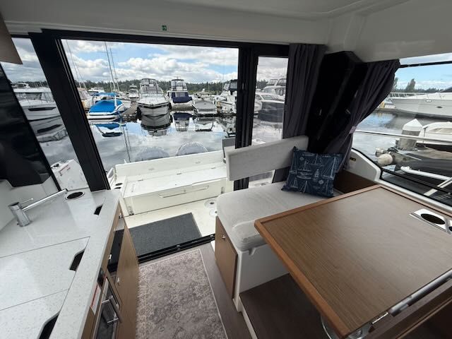 Interior of a Jeanneau NC 1095 with a view of the marina.