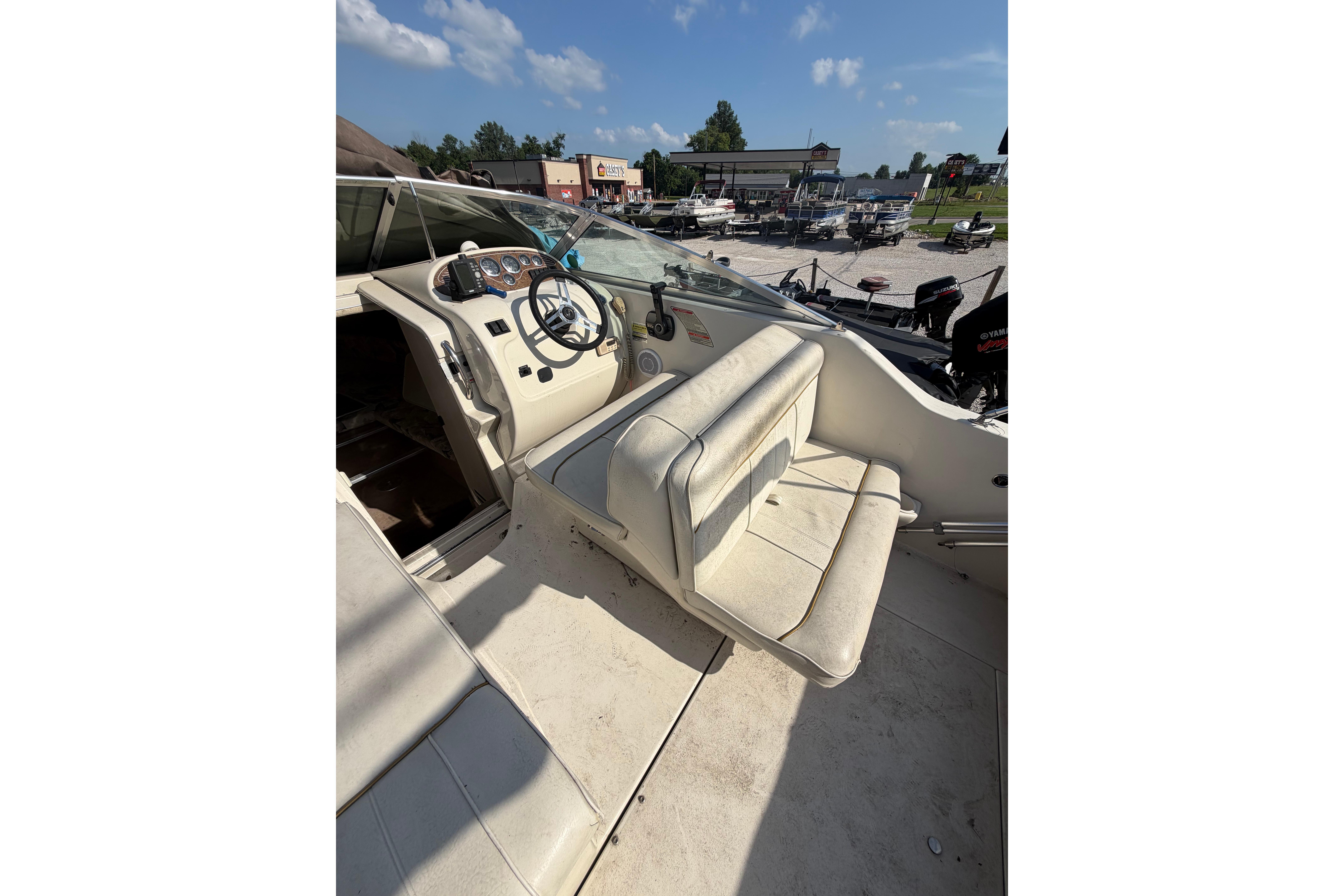 1999 Sea Ray 240 Sundancer boat interior with steering wheel and seating.