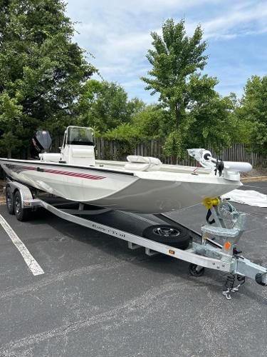 2024 Ranger RB210 boat on trailer in parking lot, surrounded by trees.