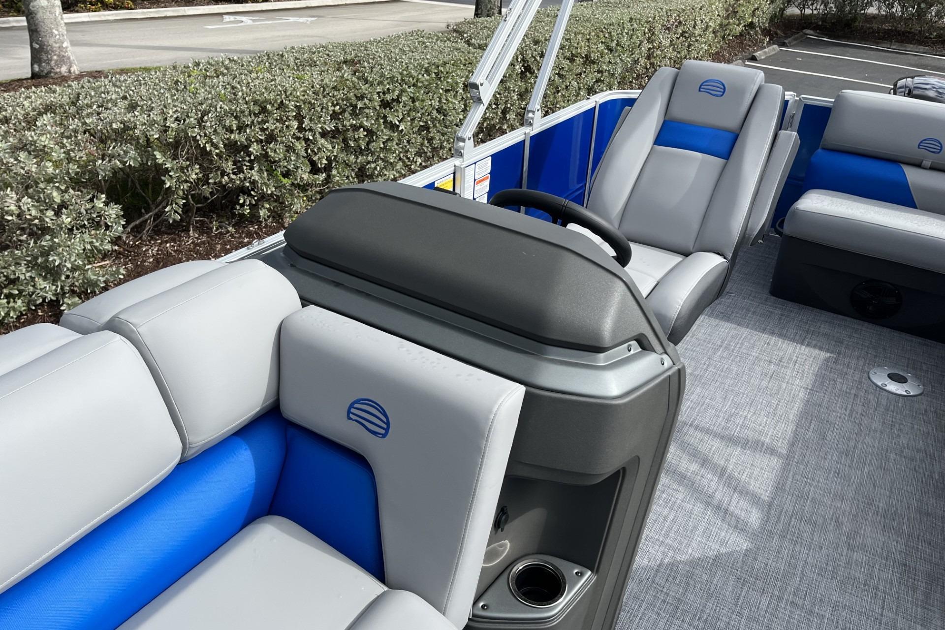 2026 Sun Tracker Party Barge 20 DLX interior with gray and blue seating, steering console.