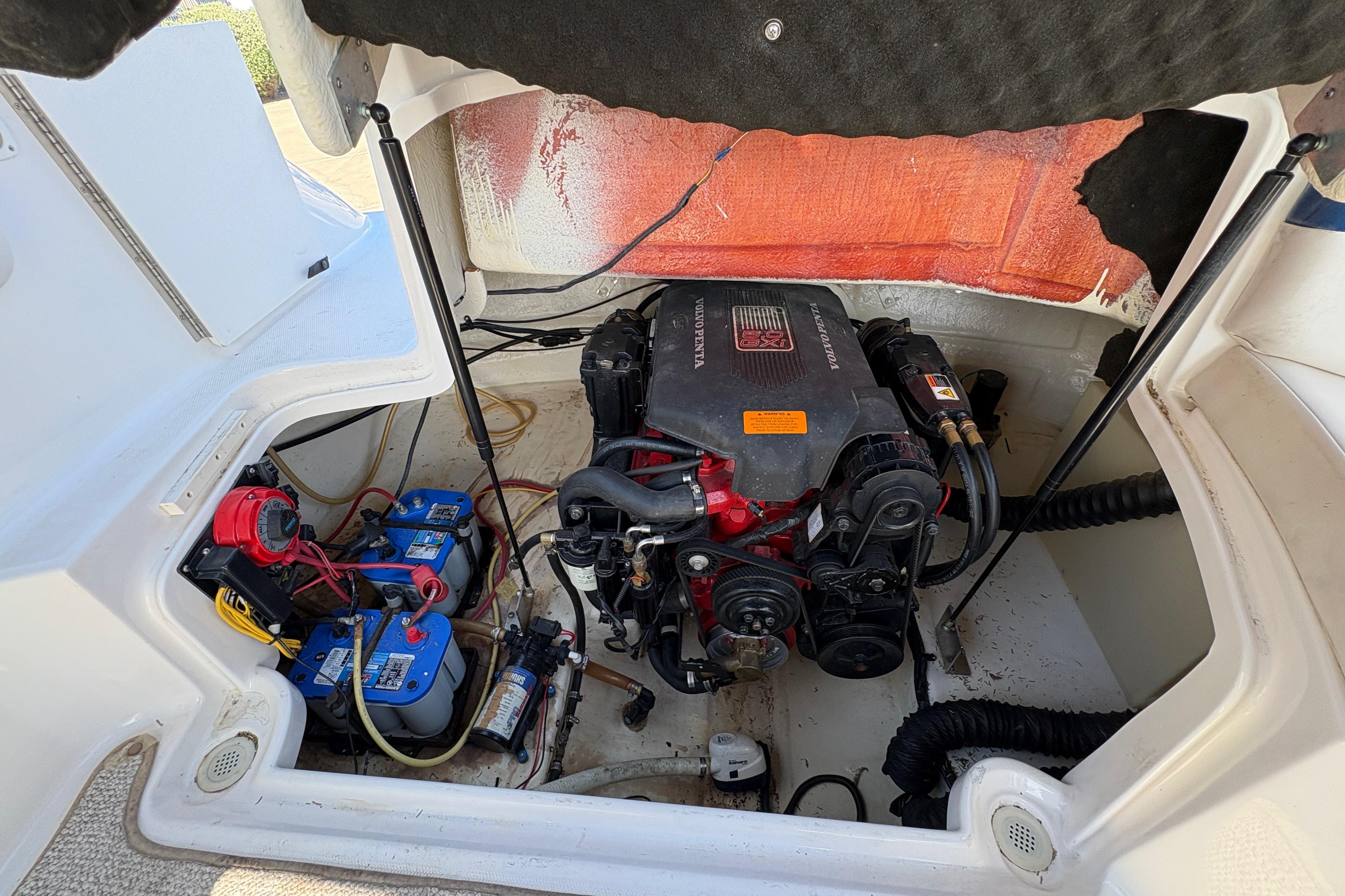Engine compartment of a 2002 Chaparral Sunesta 243 boat, featuring batteries and wiring.