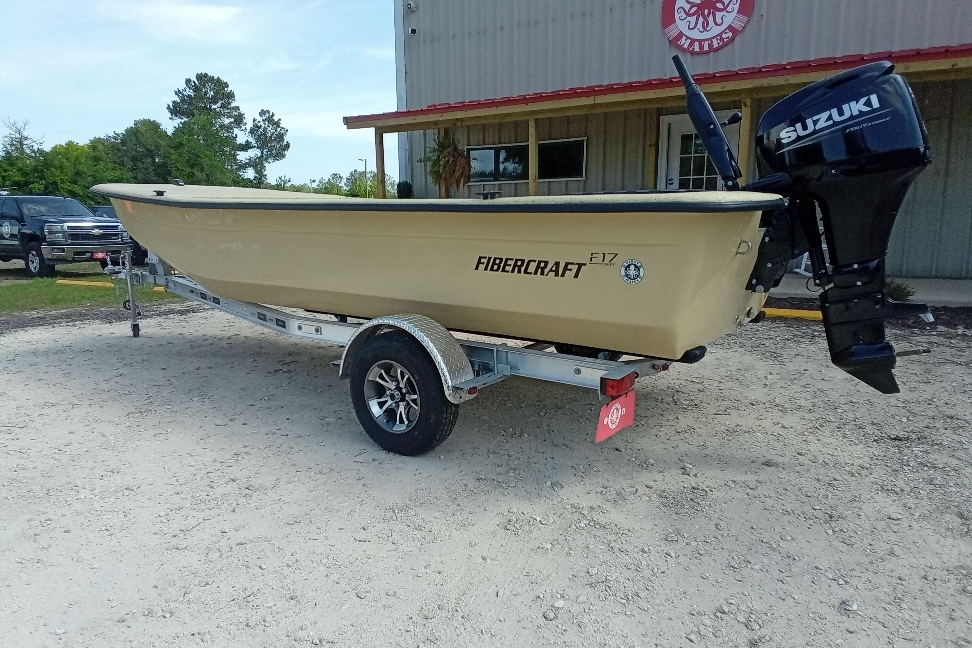 2025 Fibercraft F17 boat on trailer with Suzuki outboard motor, parked outdoors.