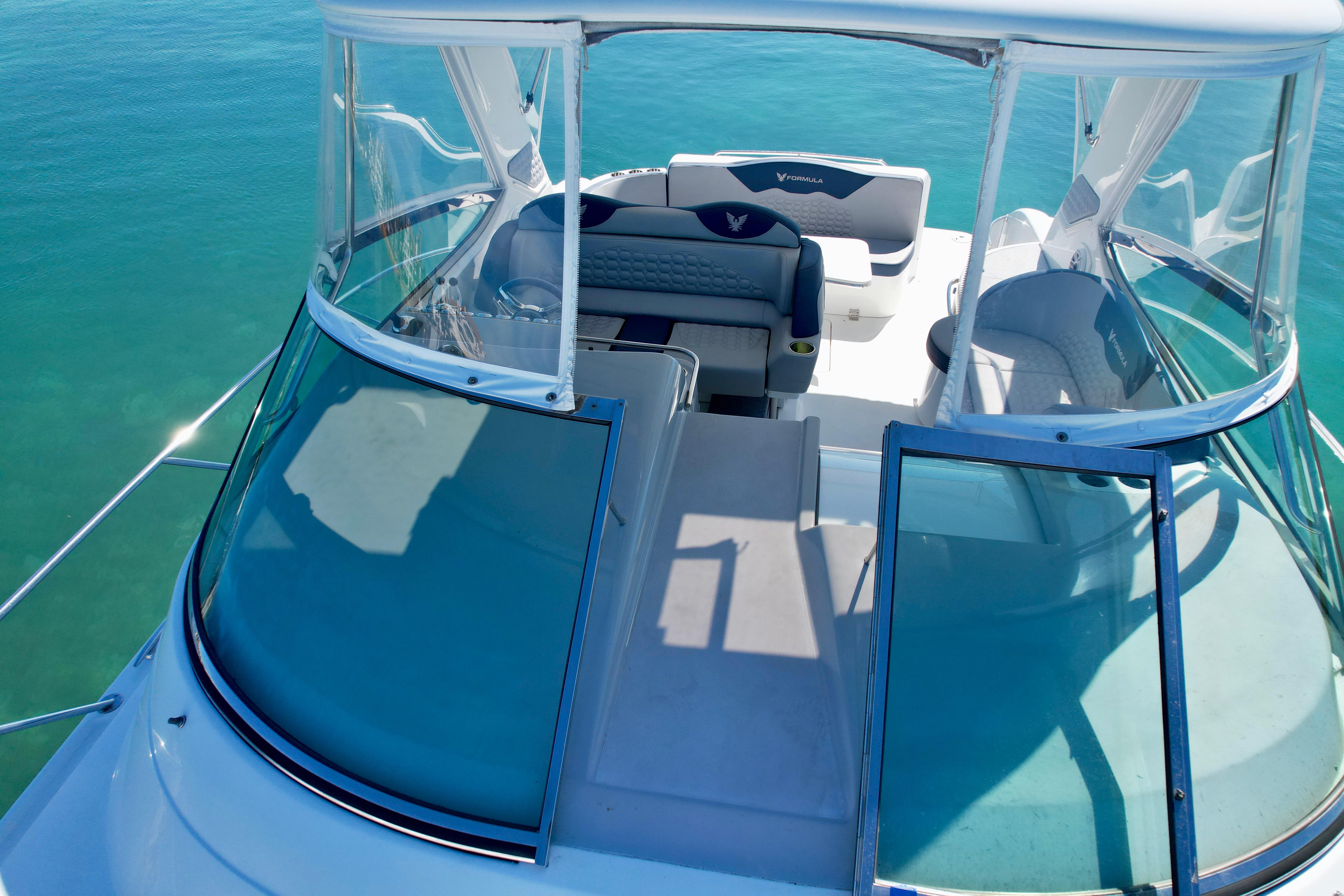 2006 Formula 40pc yacht with spacious deck and seating, cruising on clear blue water.