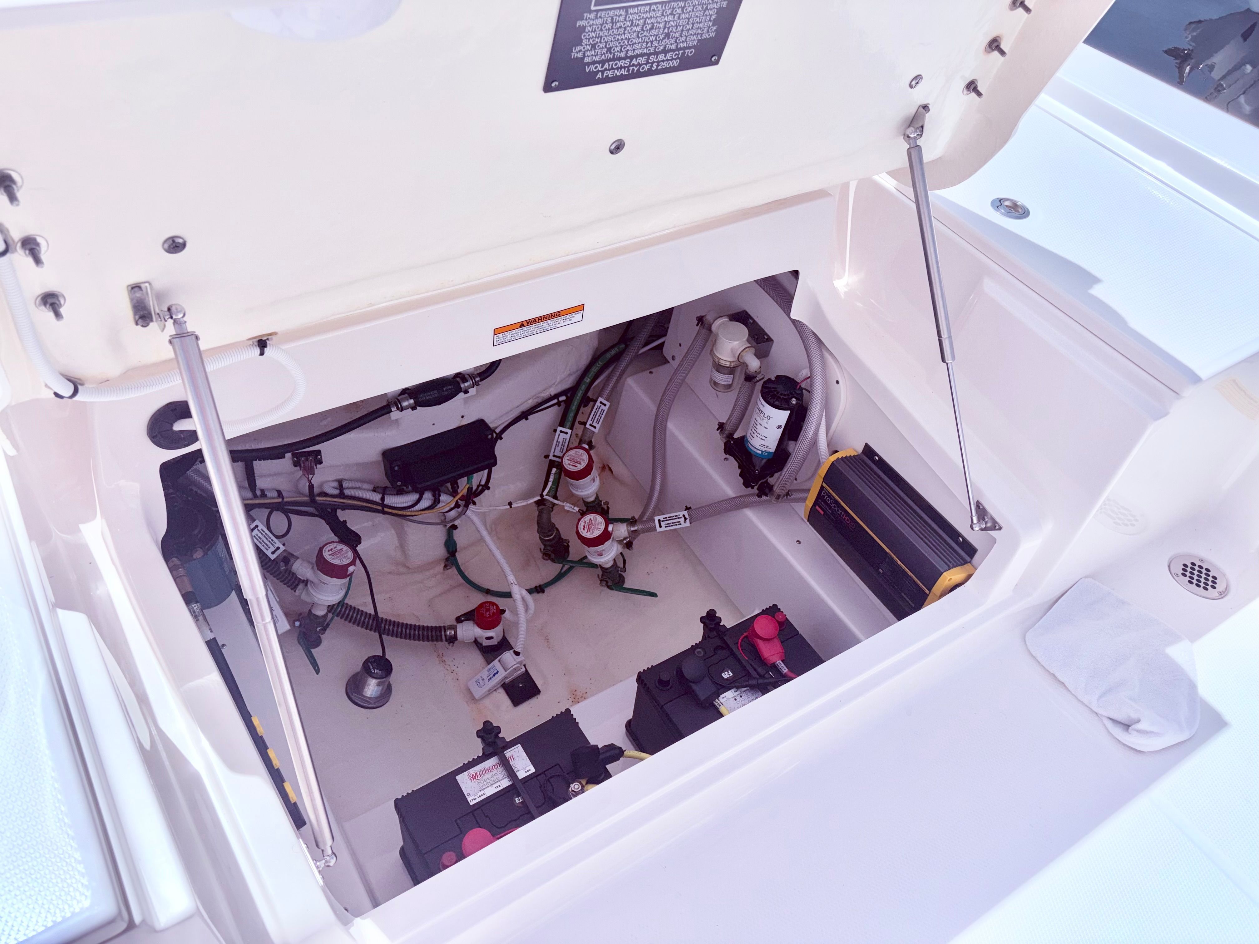 Robalo 266 Cayman 2025 engine compartment with batteries and wiring.