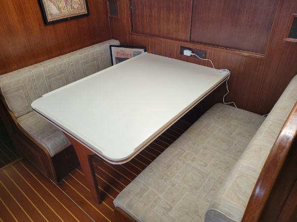 A cozy dining area with a white table and cushioned wooden benches.
