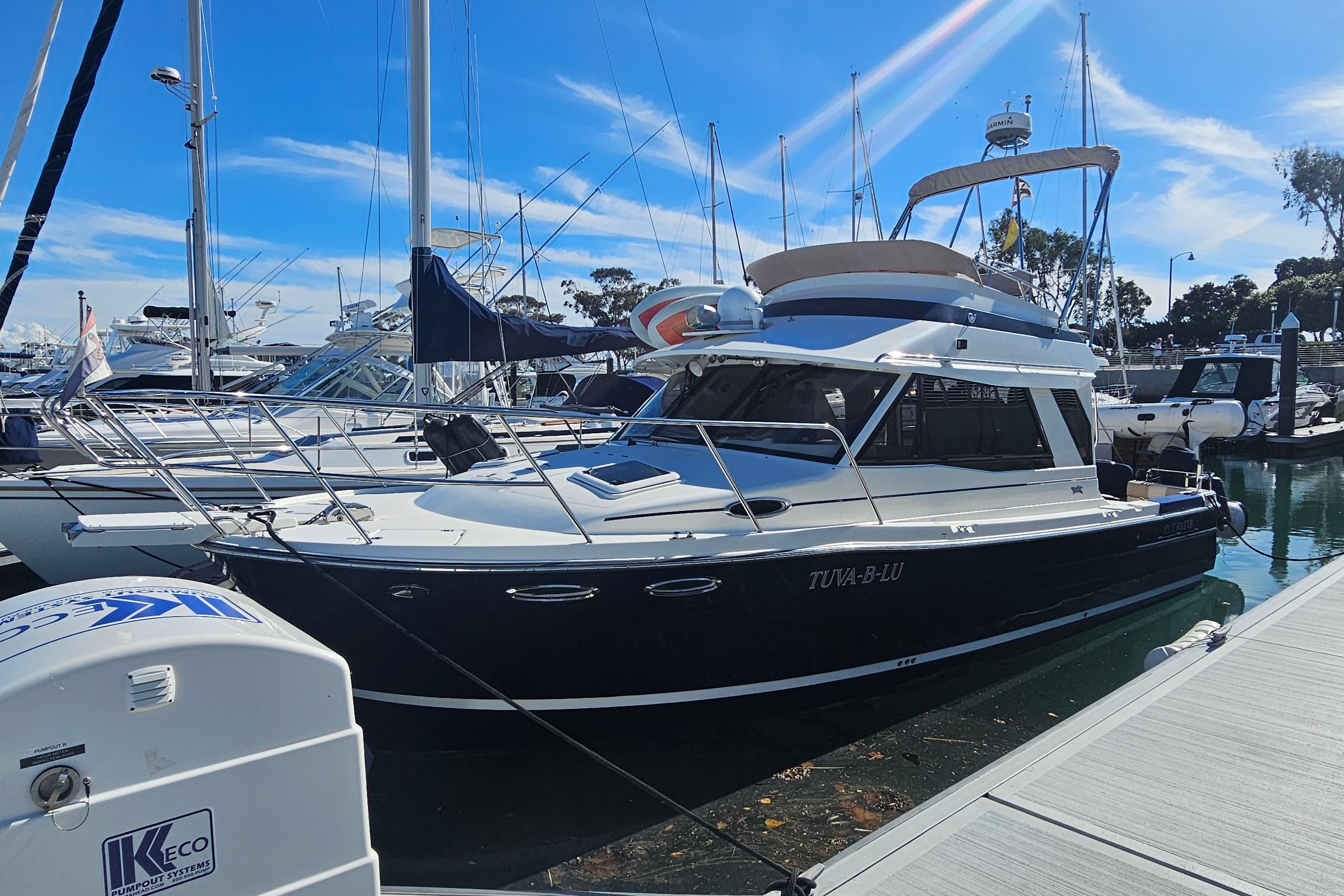 2015 Cutwater 30 Command Bridge yacht docked at marina under clear blue sky.