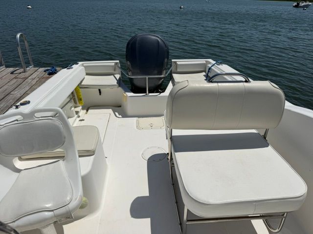 The image shows the cockpit of a 1999 Aquasport 215 DC boat with white seating.