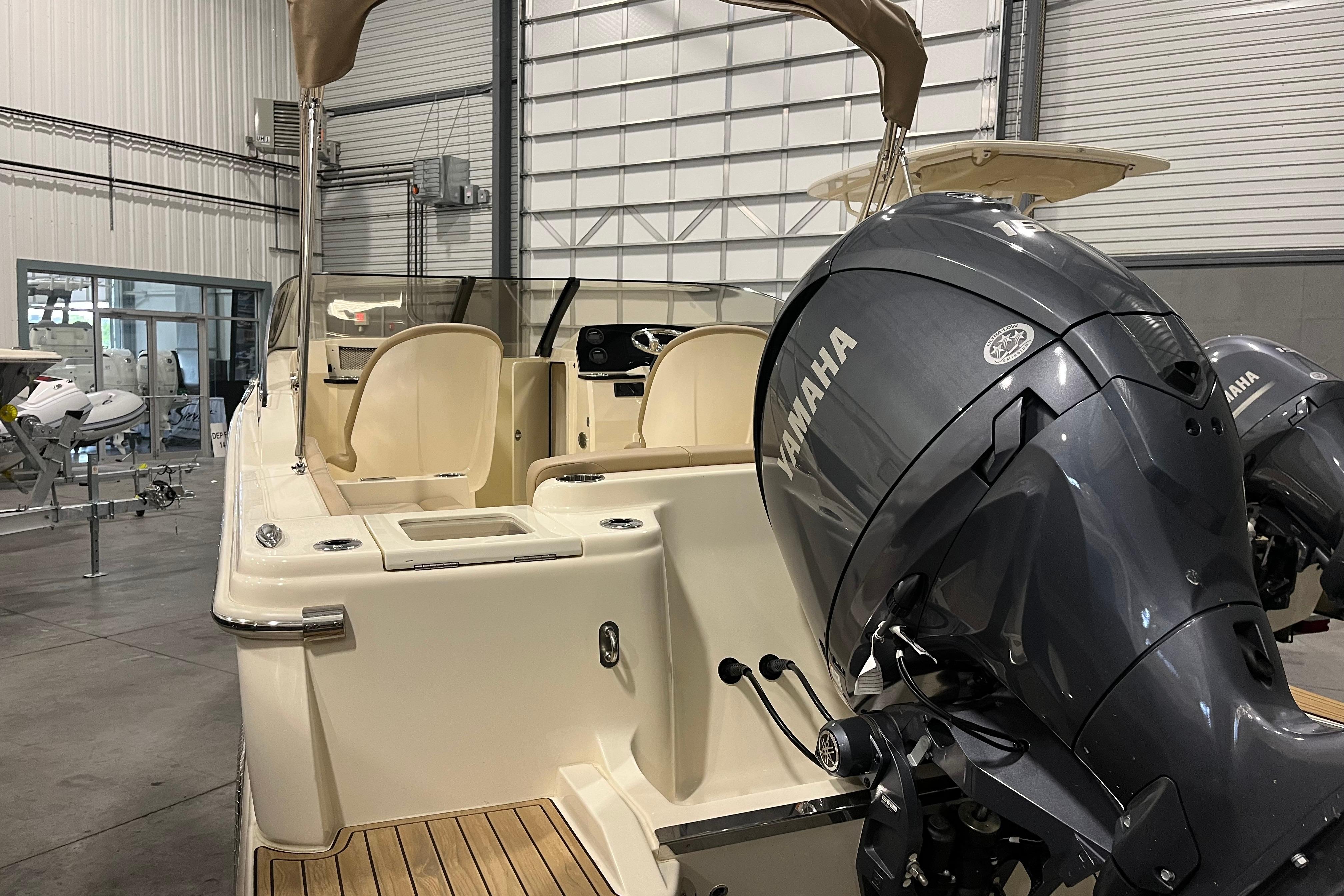 2025 Scout 215 Dorado boat with Yamaha engines in a showroom setting.