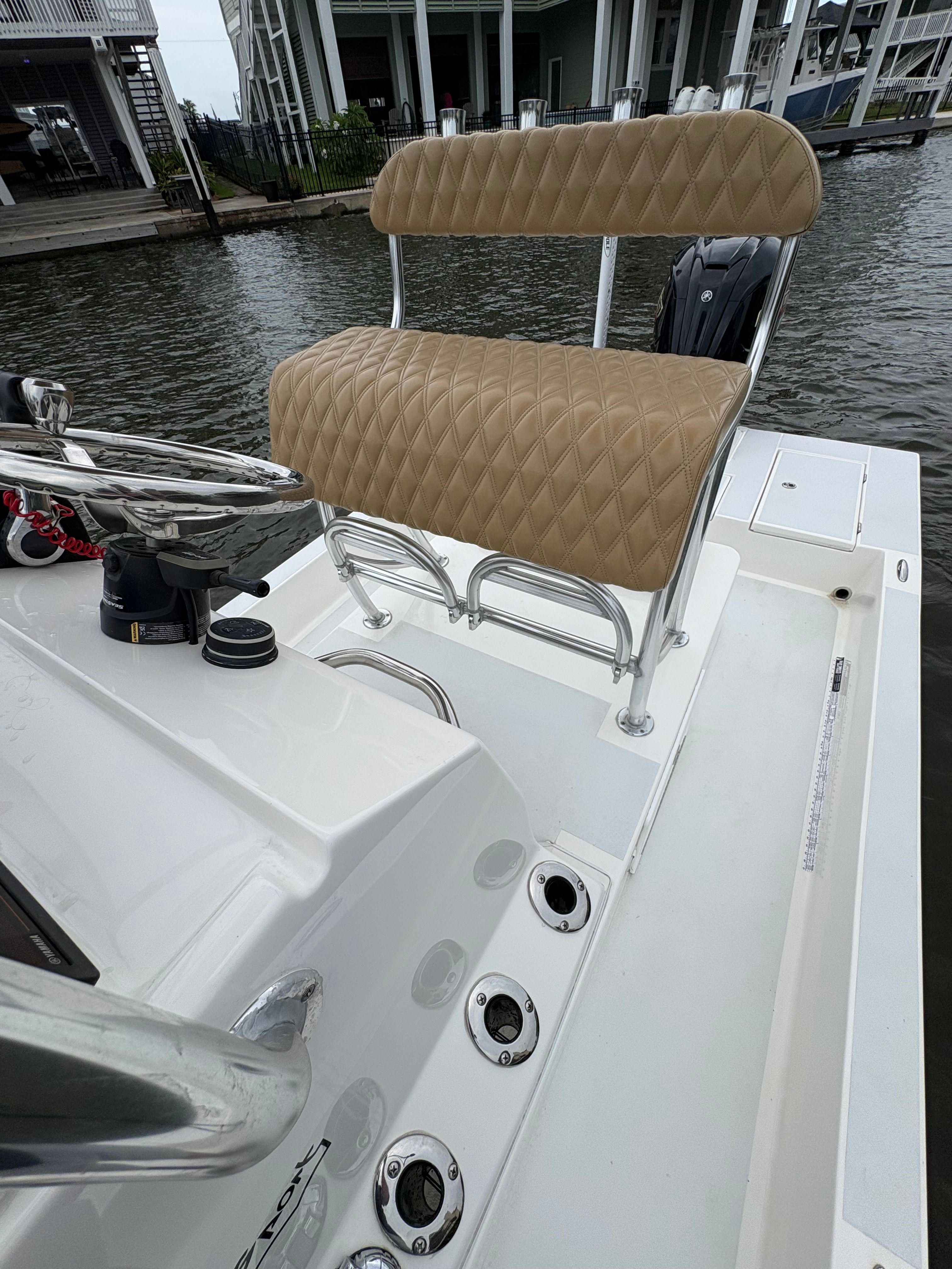 The image shows the cockpit of a Shallow Sport 24 Sport boat with cushioned seating.