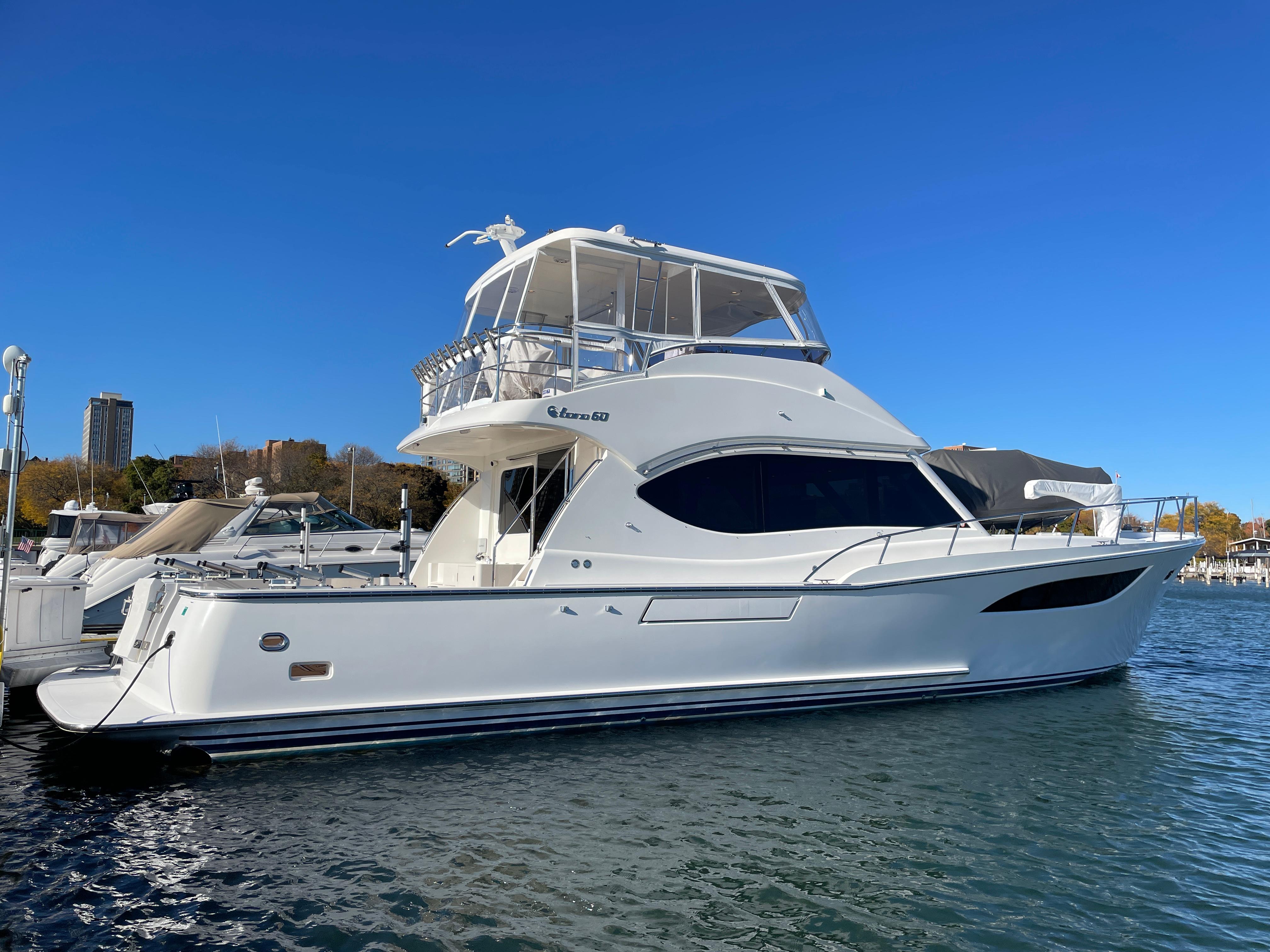 2014 Nordhavn 60 Toro Convertible yacht docked in a marina under clear blue skies.