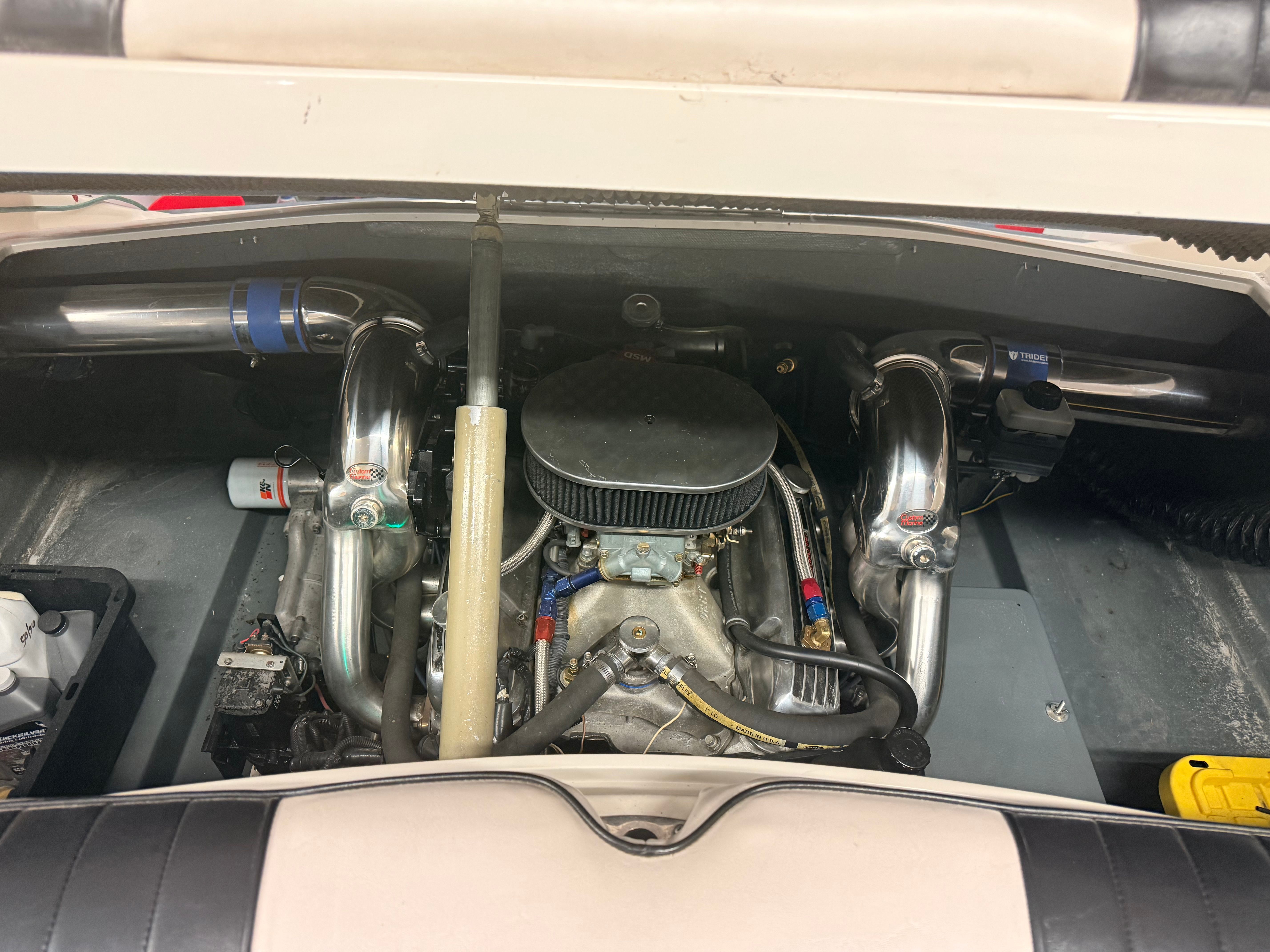 Engine compartment of a 1986 Sea Ray Pachanga 11 with shiny metal parts and hoses.