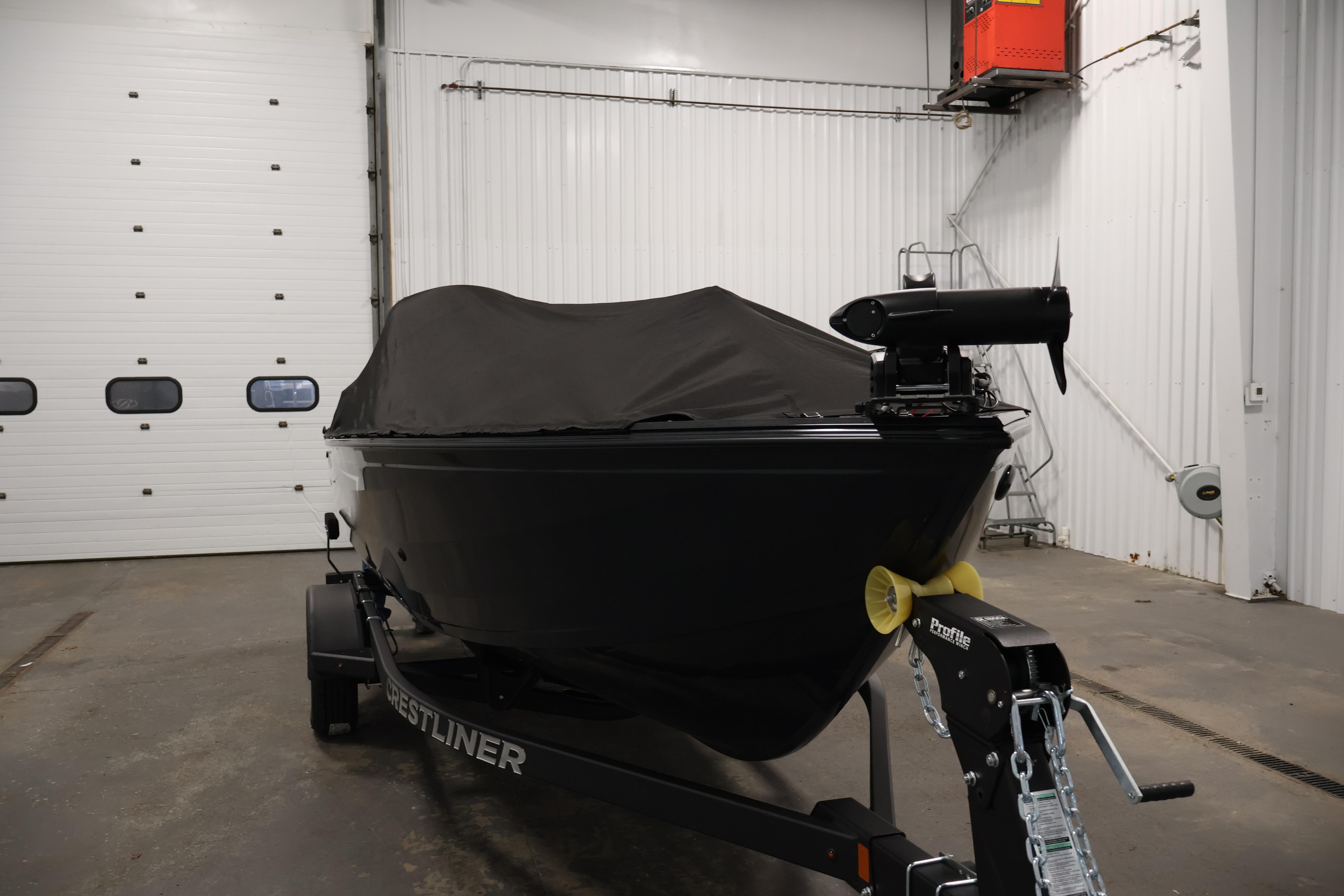 2026 Crestliner 1850 Kodiak SC boat covered in a garage, on a trailer.