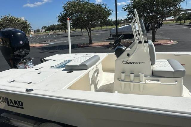 2026 Mako 18 Pro Skiff boat with seating and console in a parking lot.