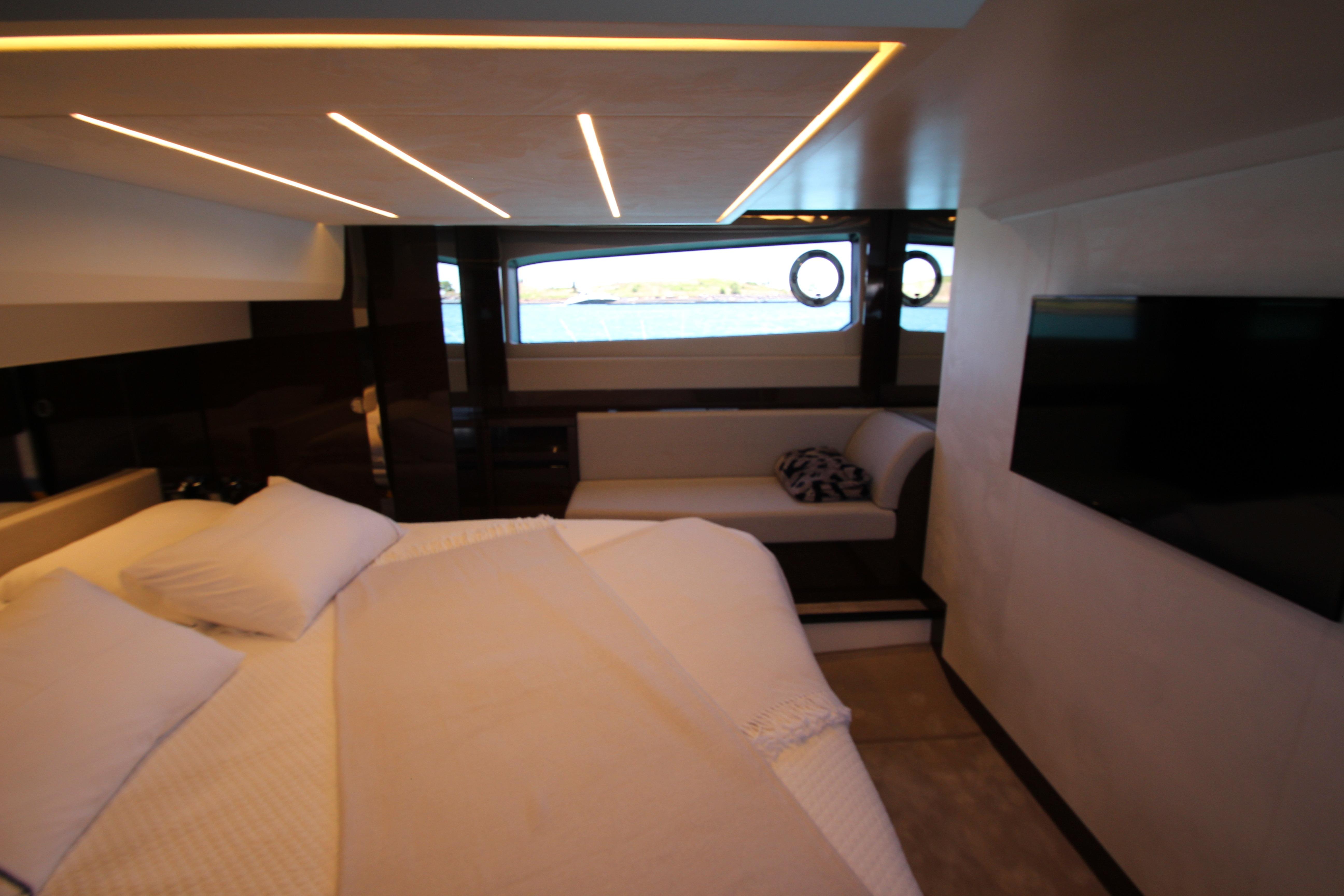 Luxurious interior of 2022 Prestige 520 yacht with modern bedroom and scenic window view.
