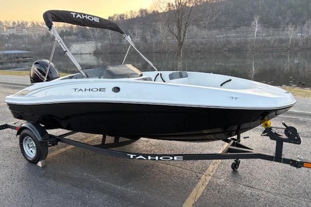 2026 Tahoe T16 boat on trailer by a riverside, showcasing sleek design.
