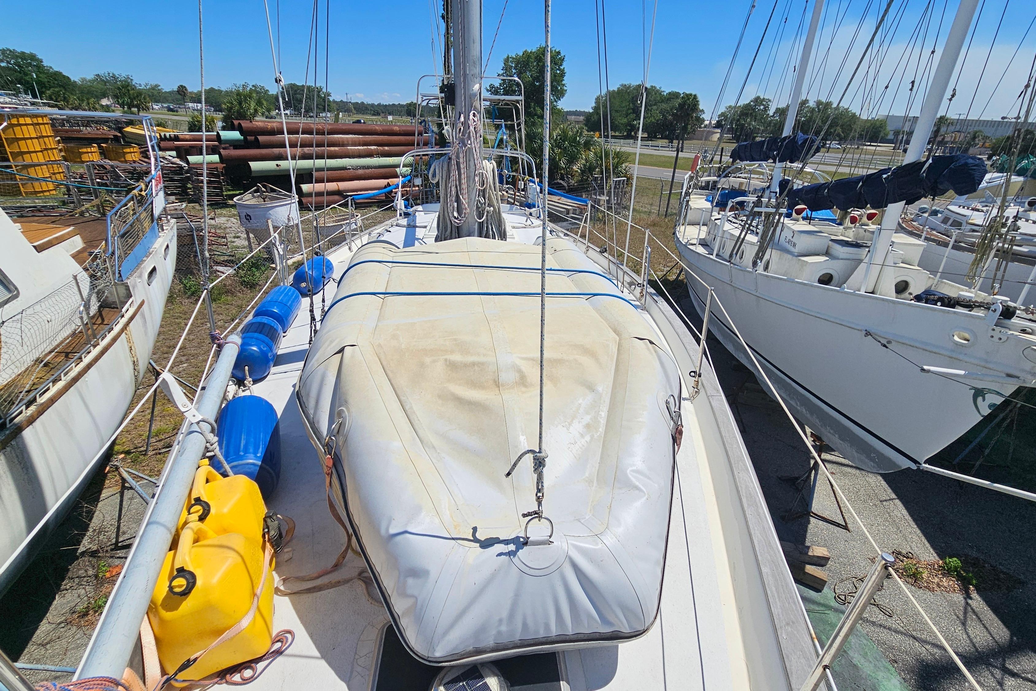1979 Morgan 382 sailboat on deck, surrounded by other boats in a marina.