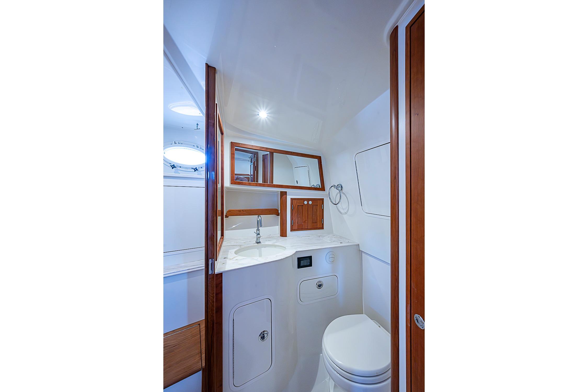 Luxurious bathroom interior of 2023 Hinckley Sport Boat 40 X, featuring modern fixtures and wood accents.