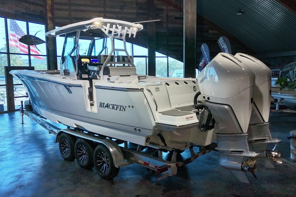 2023 Blackfin 302 CC boat on trailer in showroom with dual outboard engines.