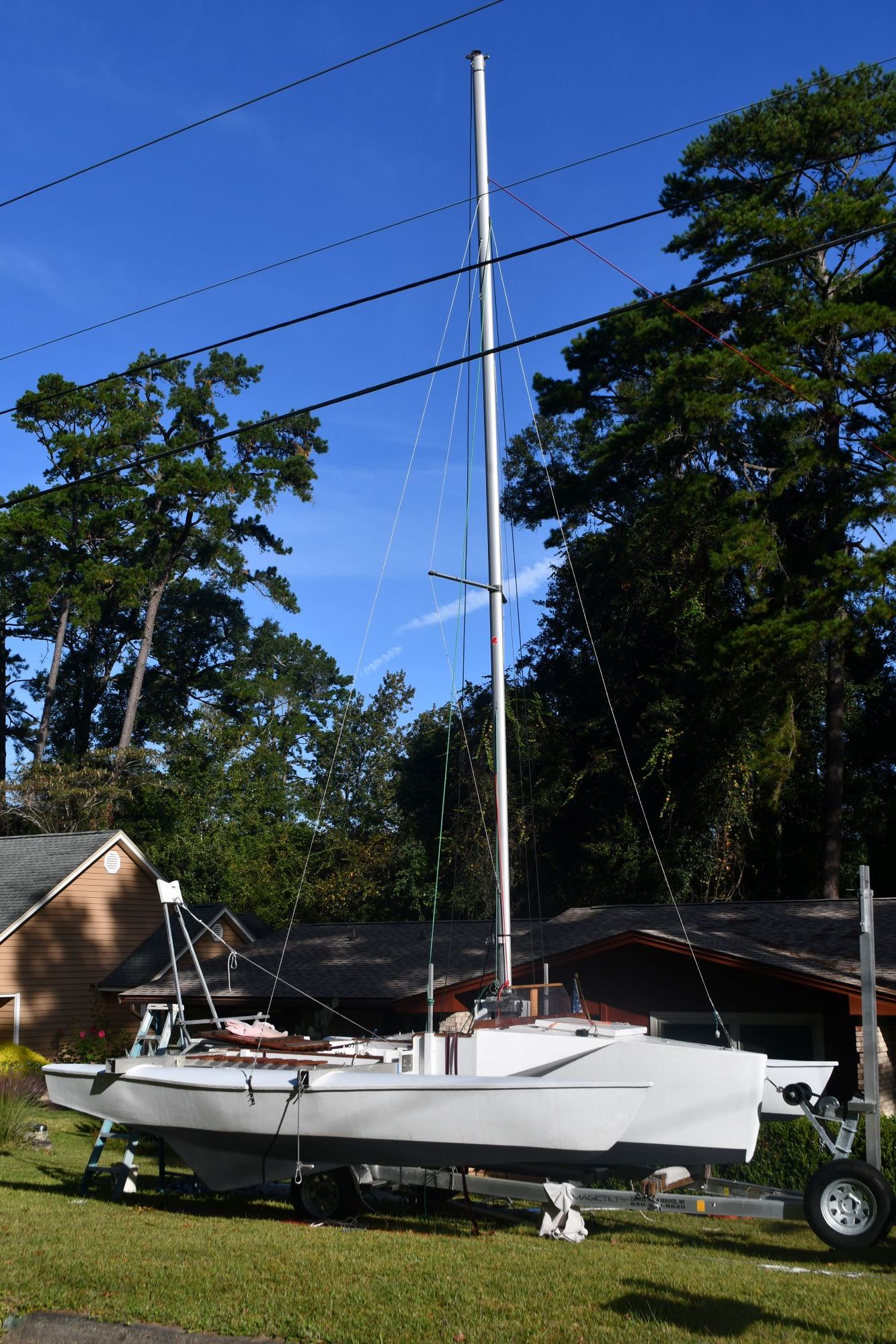 Custom Strike 18 sailboat from 2020 on trailer in yard.