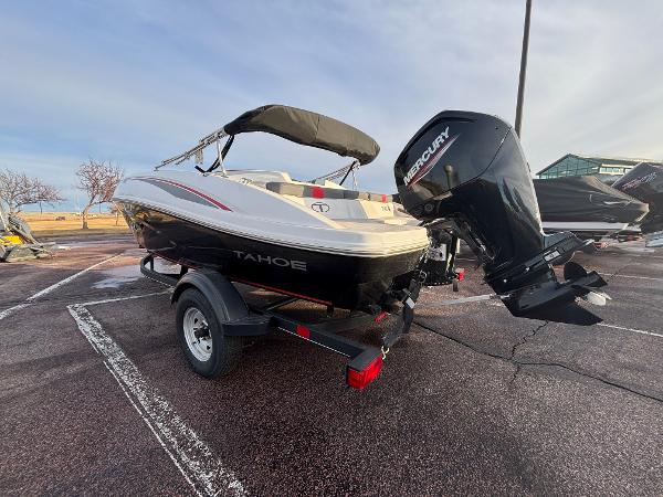 2023 Tahoe T16 boat with Mercury outboard motor on trailer in parking lot.