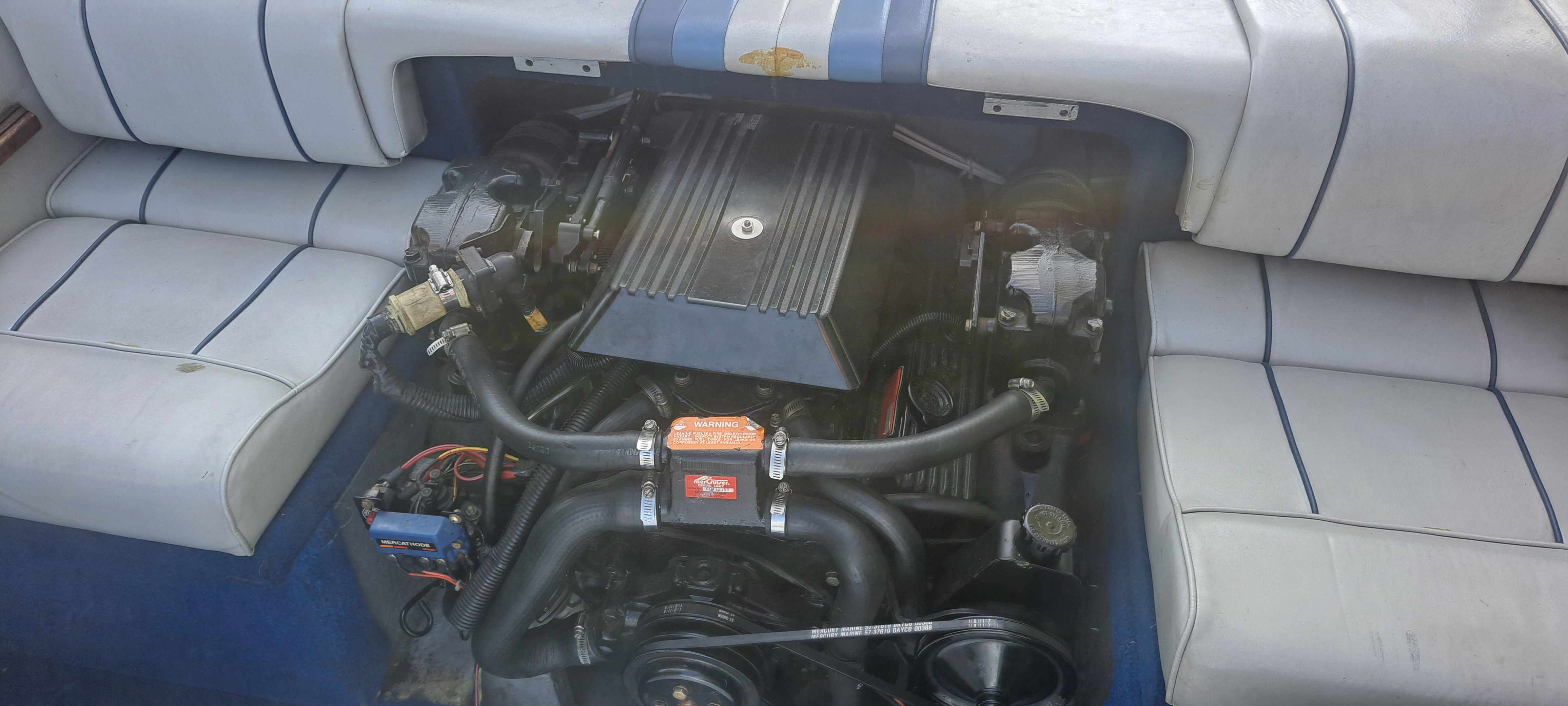Engine compartment of a 1988 Sea Ray Sevville boat with cushioned seats.