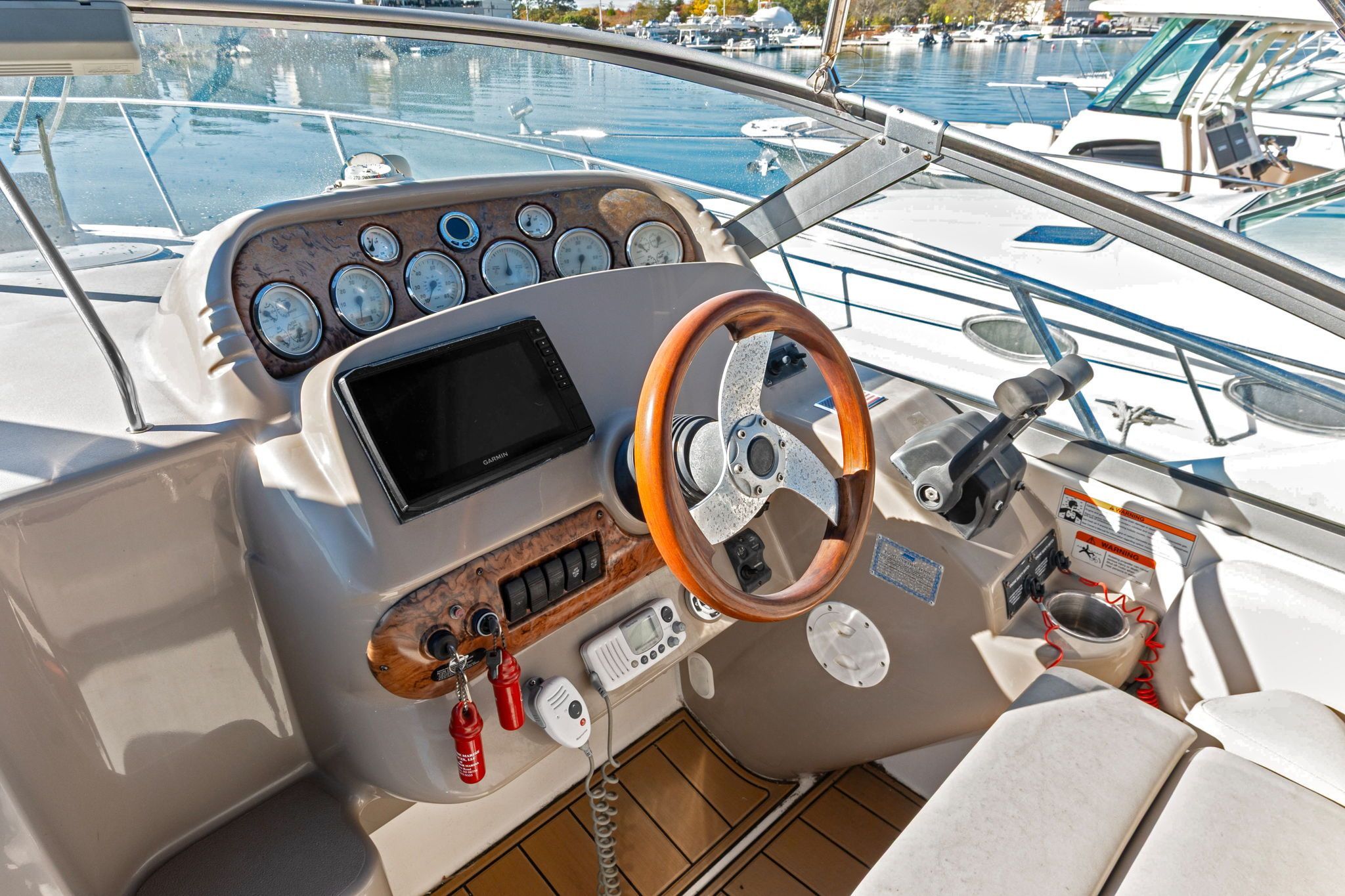 The image shows the helm of a 2007 Larson Cabrio 330 with a wood steering wheel and instruments.