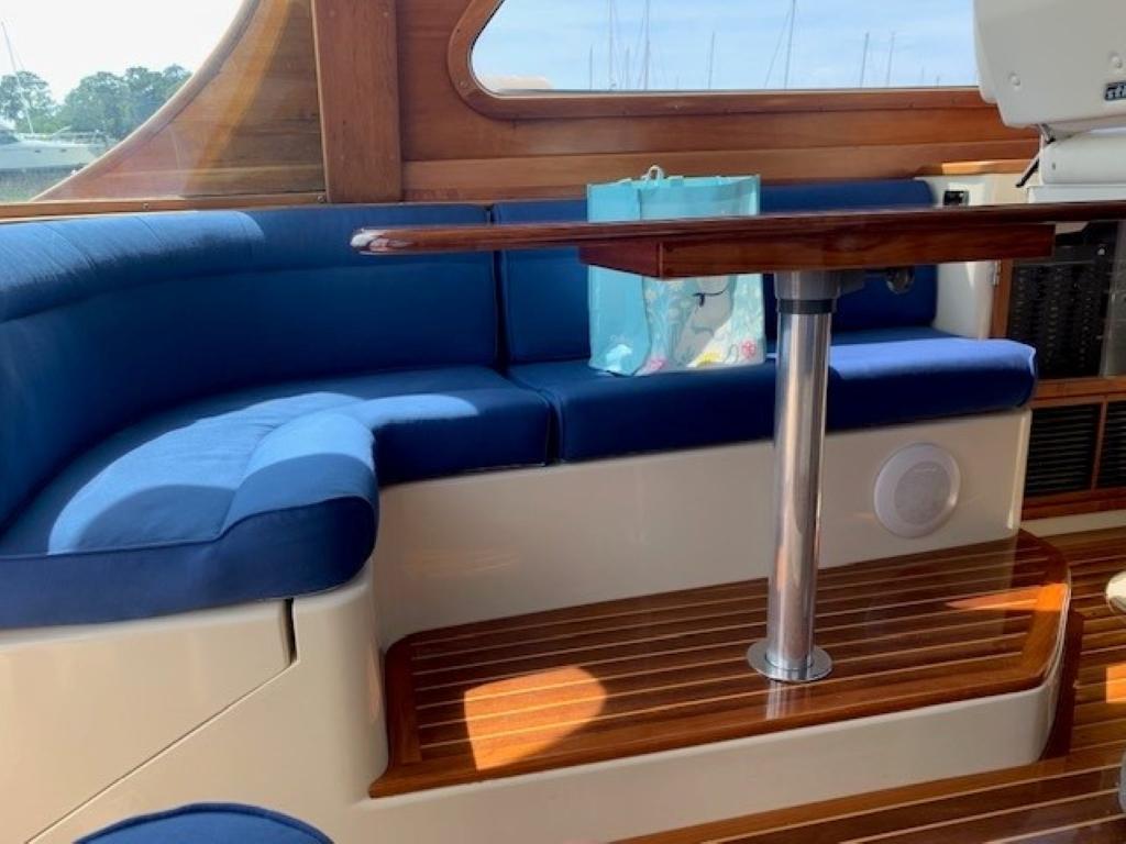 Interior of 2002 Hinckley Talaria 44 FB with blue seating and wooden table.
