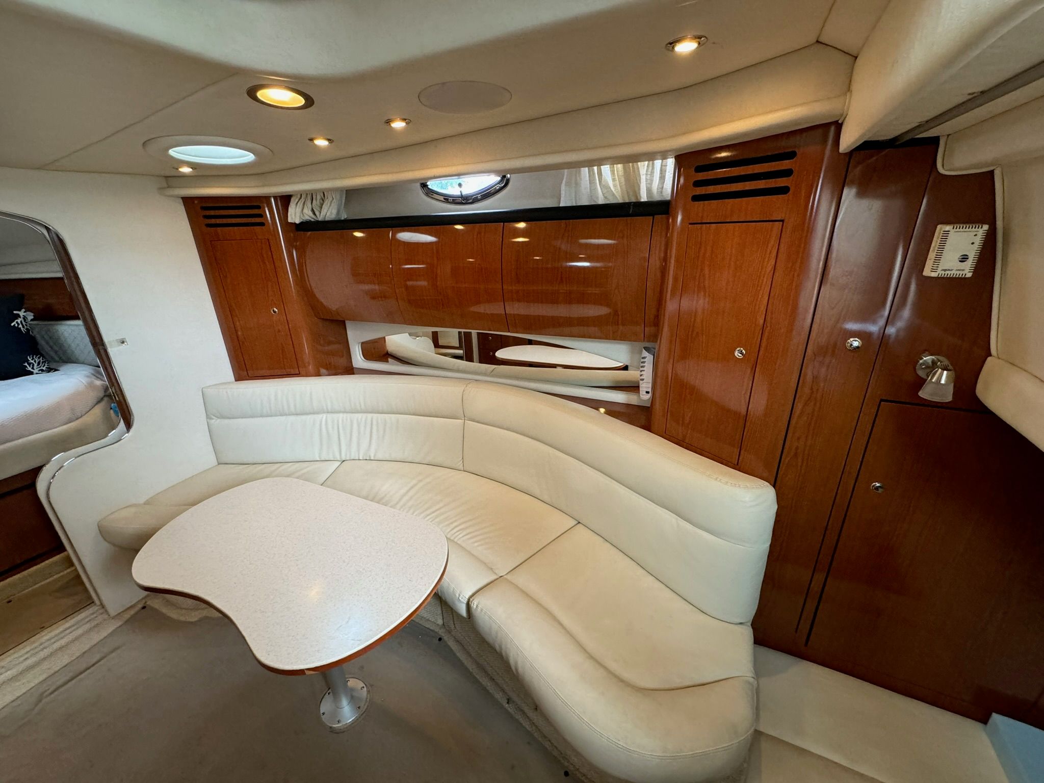 Interior of 2002 Sea Ray 360 Sundancer with leather sofa and wooden cabinetry.