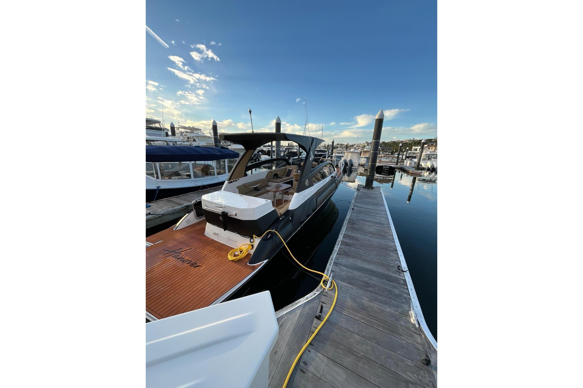 Luxury Hanover 305 yacht docked at marina, 2026 model, under clear blue sky.
