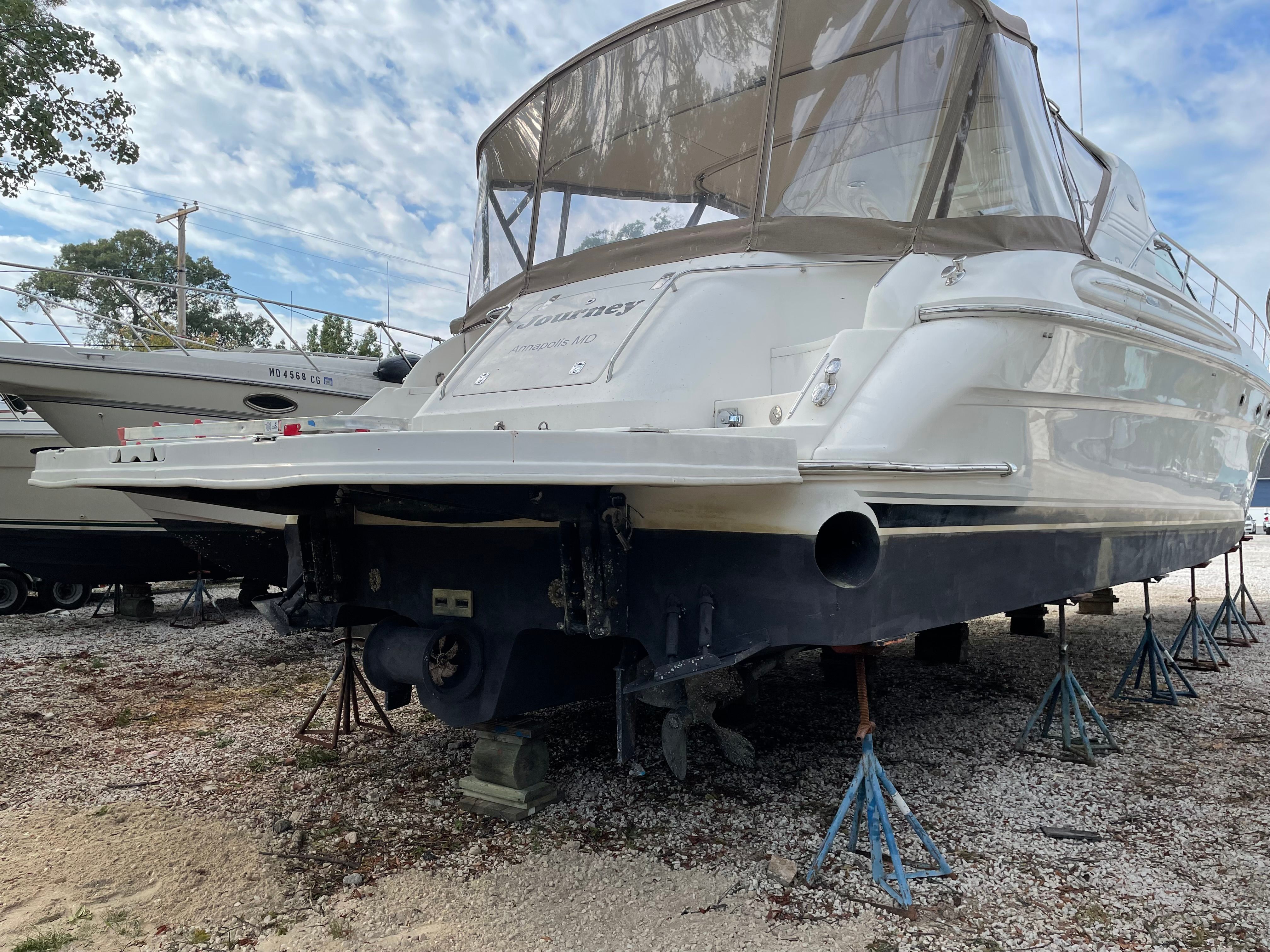 A 2003 Sea Ray S600 Sunsport is supported on stands on land.