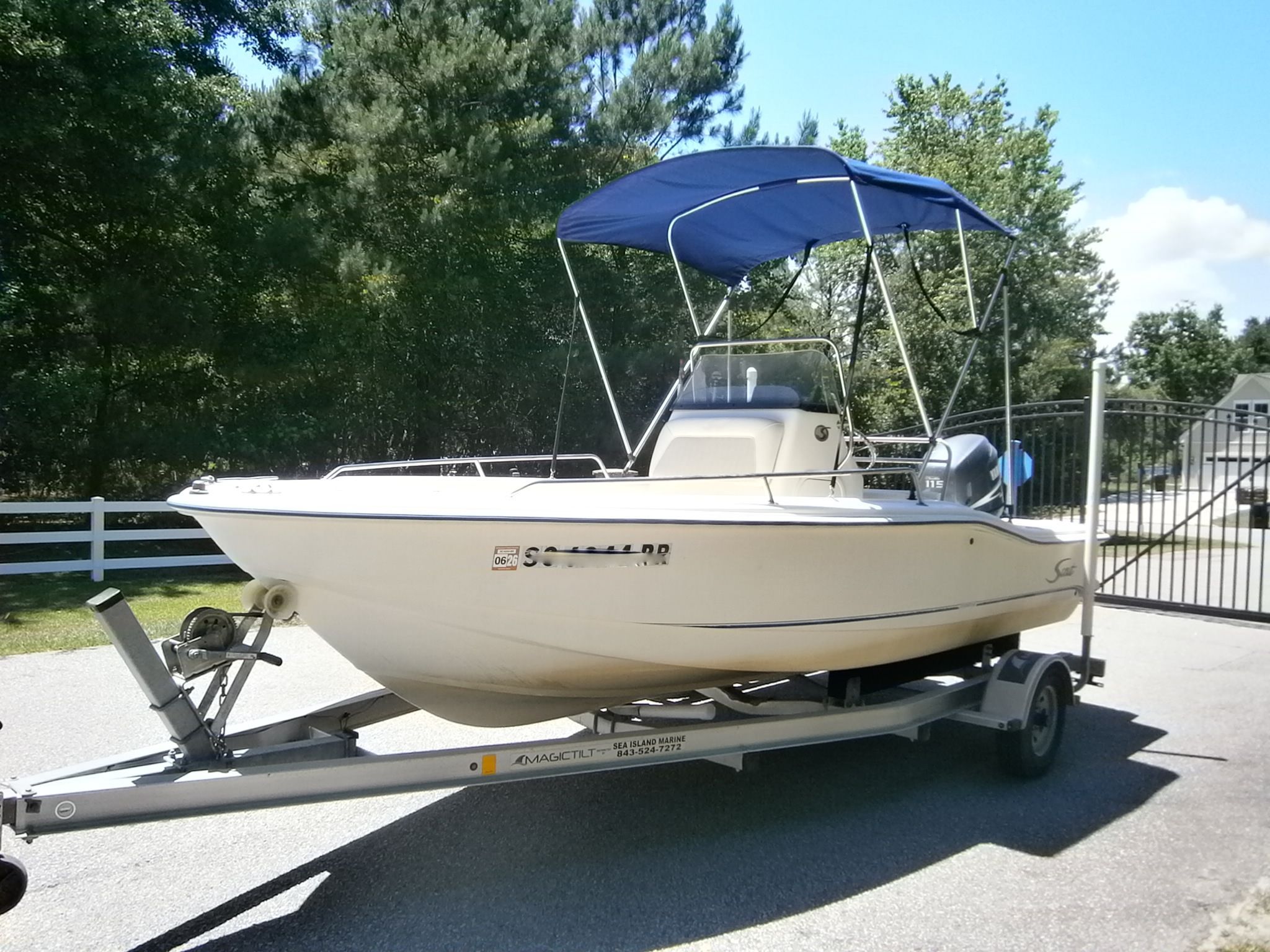 2004 Scout 175 Sportfish boat on trailer outdoors.