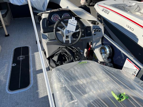 2025 Harris Cruiser 230 boat interior with steering wheel and dashboard controls.