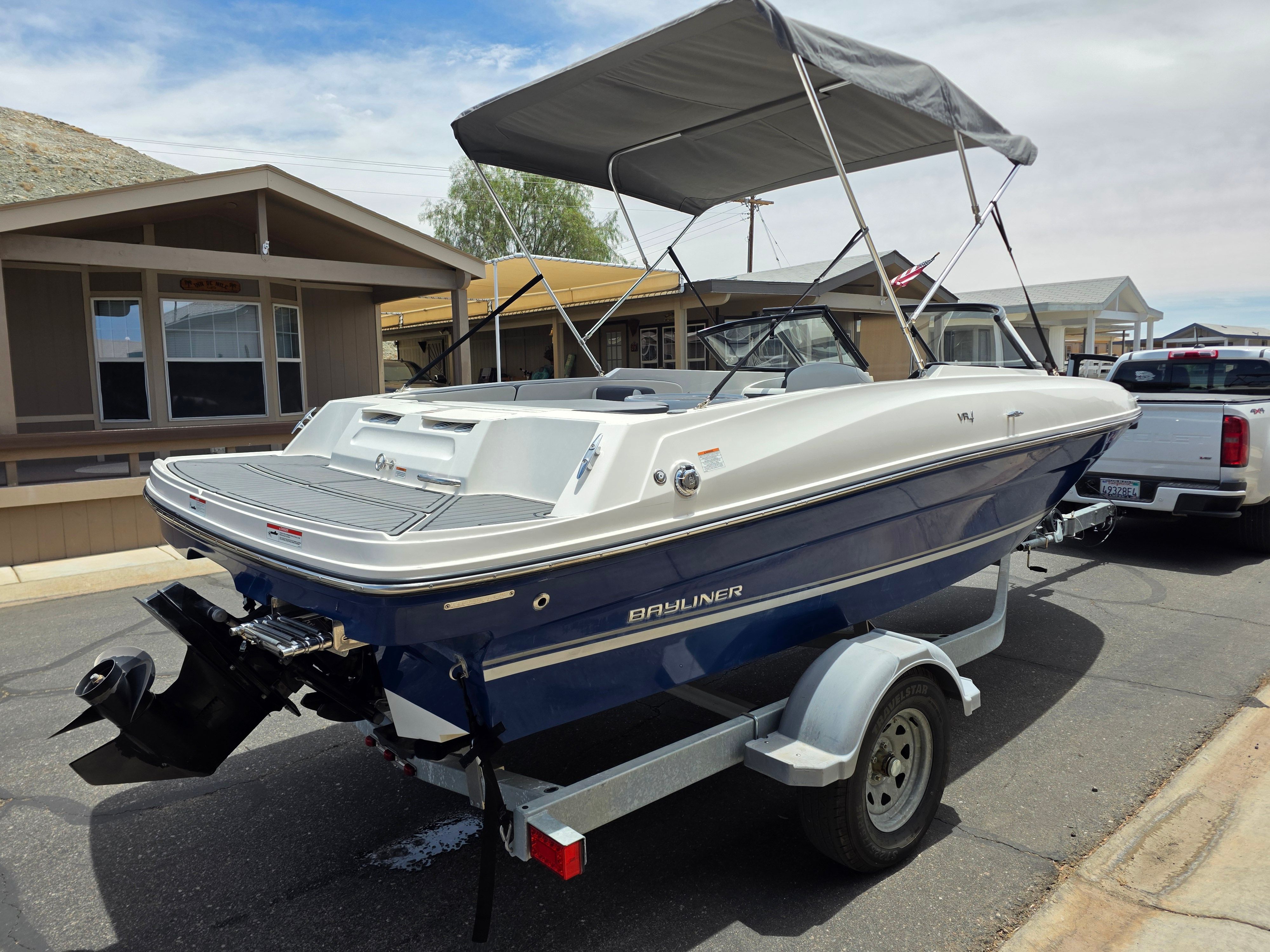 A 2021 Bayliner VR4 Bowrider I/O on a trailer in a residential area.