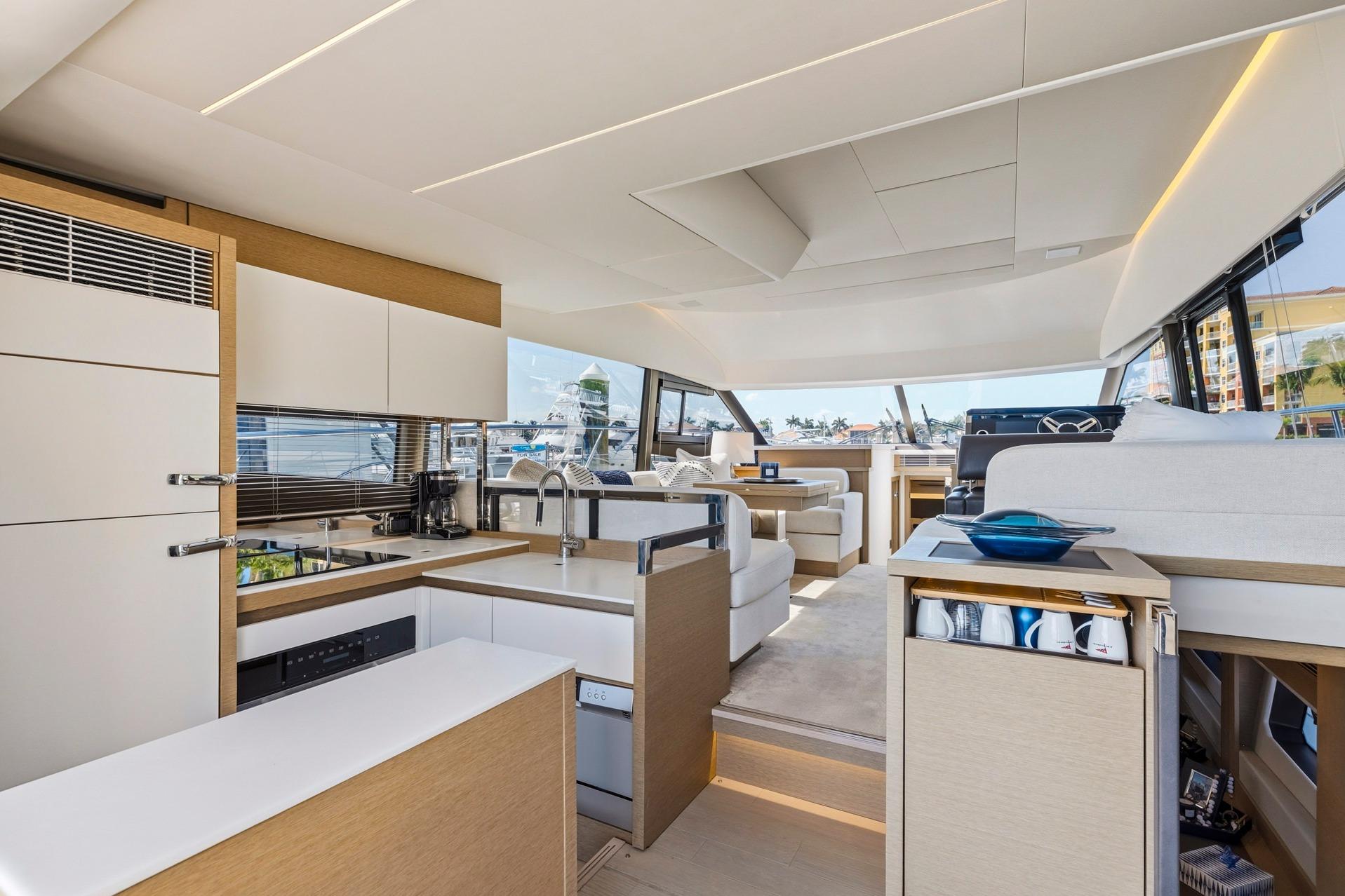 Luxurious interior of 2022 Prestige 520 yacht featuring modern kitchen and spacious seating area.