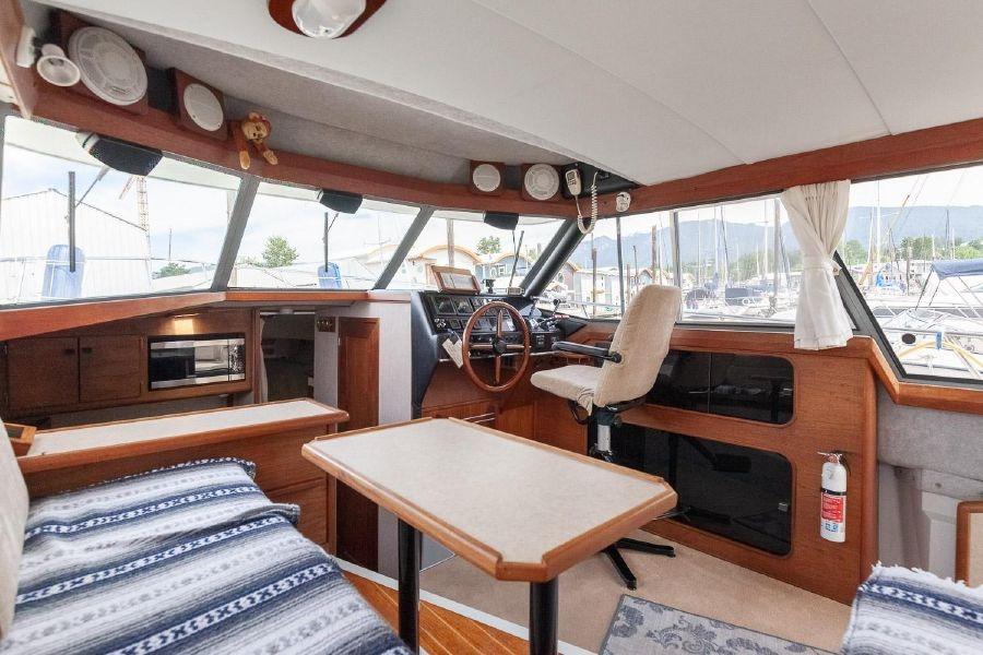 Interior of 1987 Bayliner 3270 Motoryacht with helm, seating, and panoramic windows.