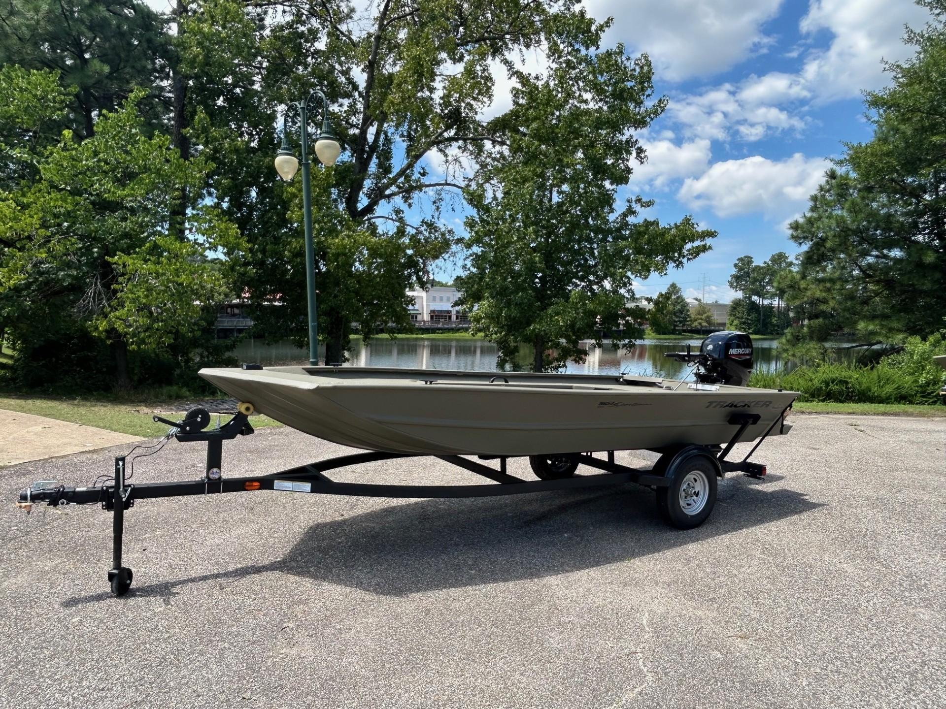 2025 Tracker Grizzly 1654 T Sportsman boat on trailer, parked near a scenic lake.