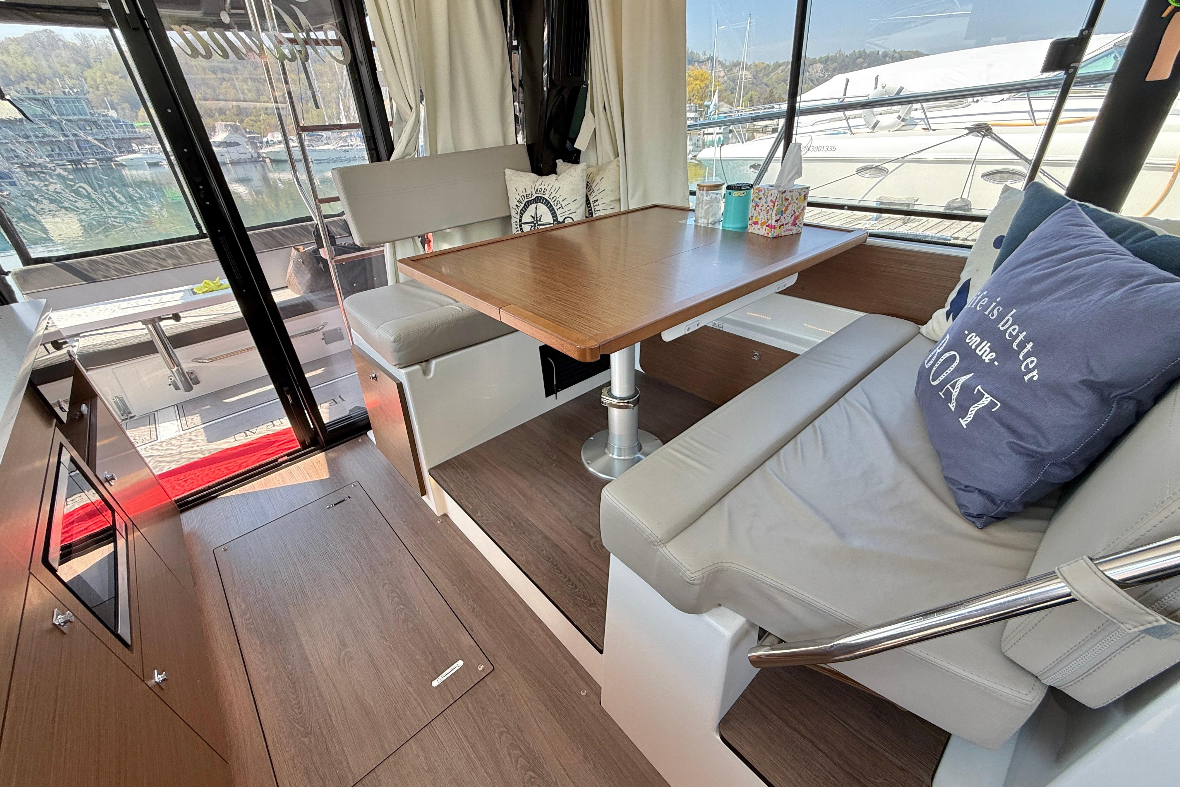 Interior of 2022 Jeanneau NC 1095 Fly, featuring cozy seating and dining area.
