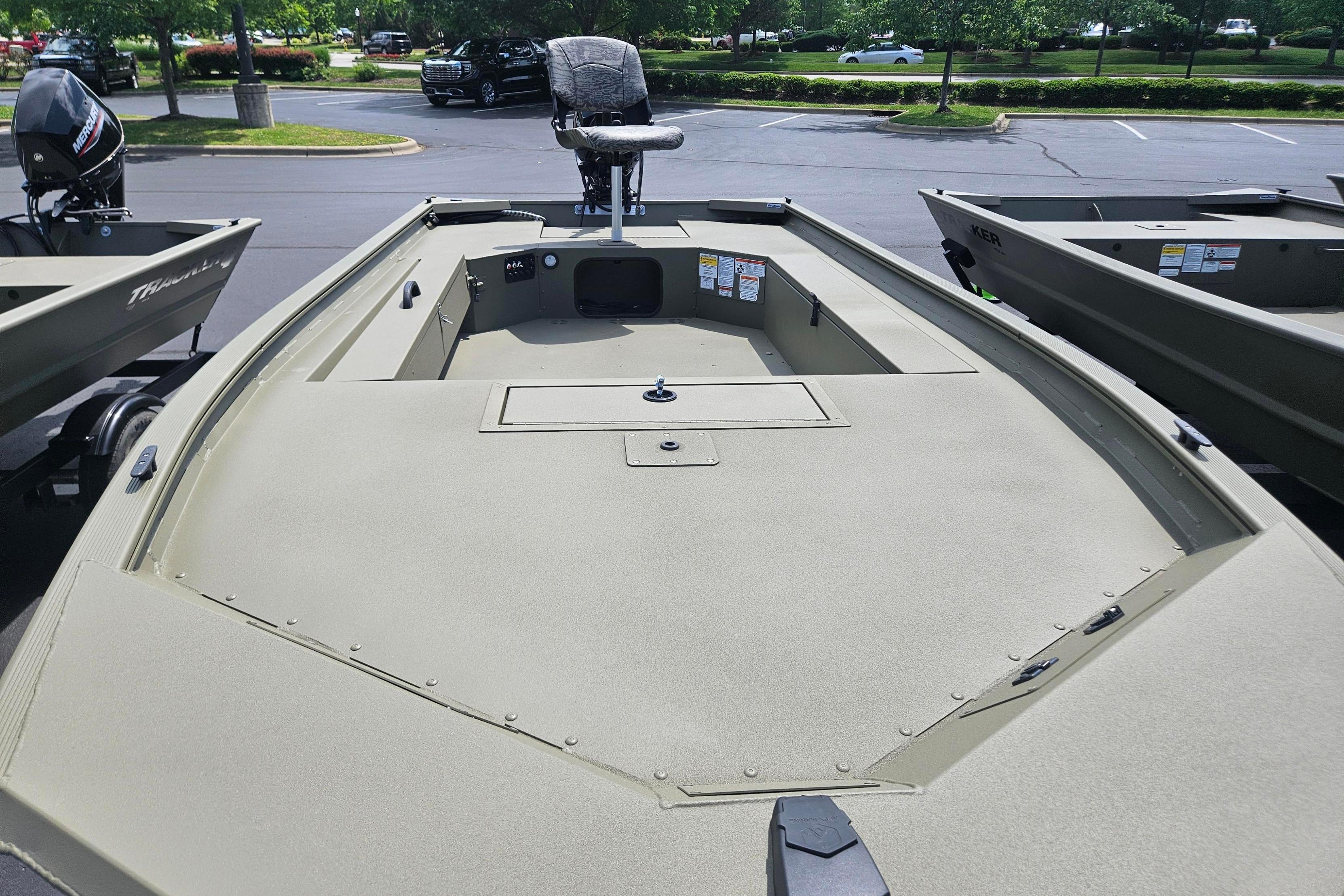 2026 Tracker Grizzly 1654 T Sportsman boat in parking lot, featuring spacious deck and seating.