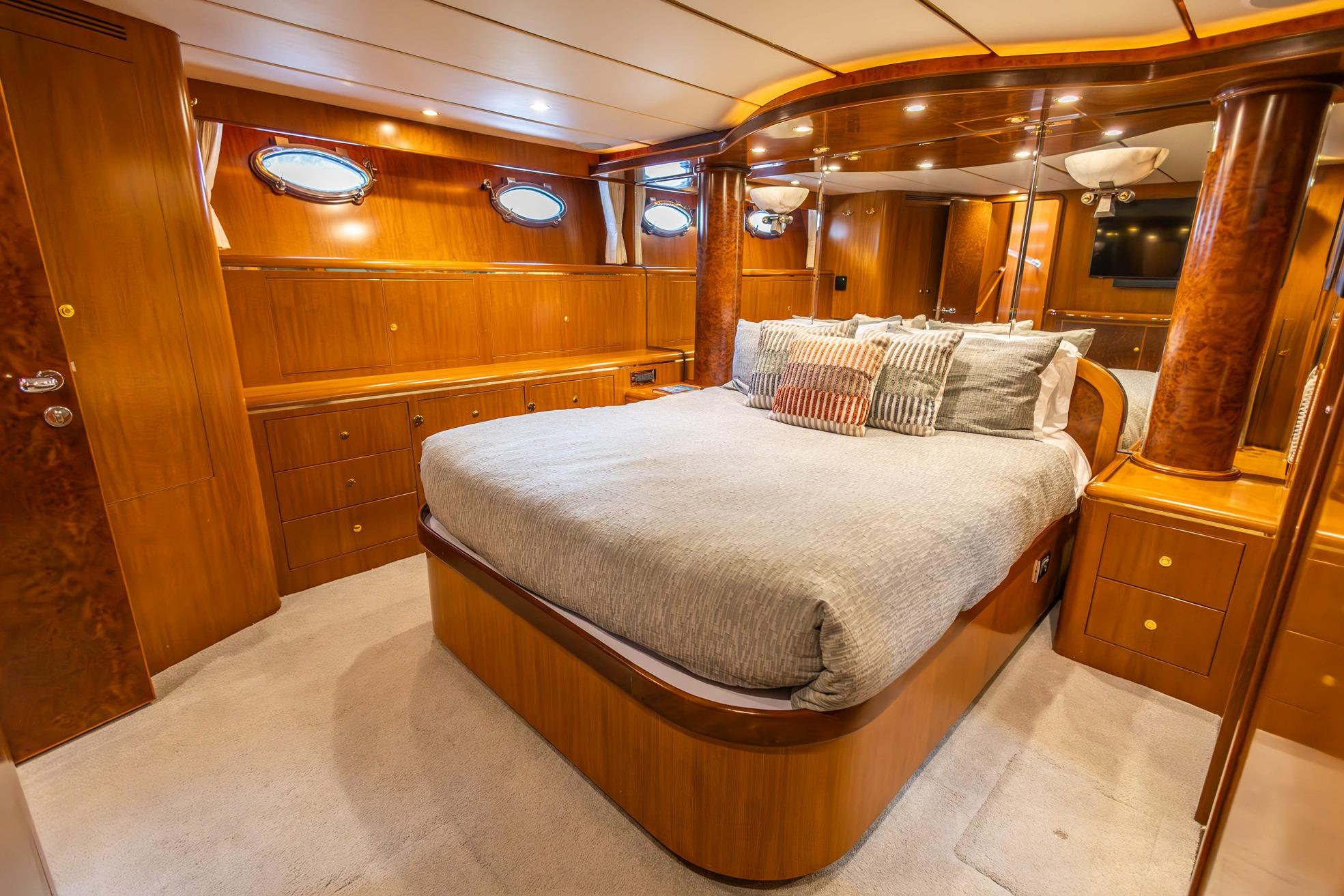 Luxurious 2005 Ocean Alexander yacht bedroom with elegant wood finishes and plush bedding.