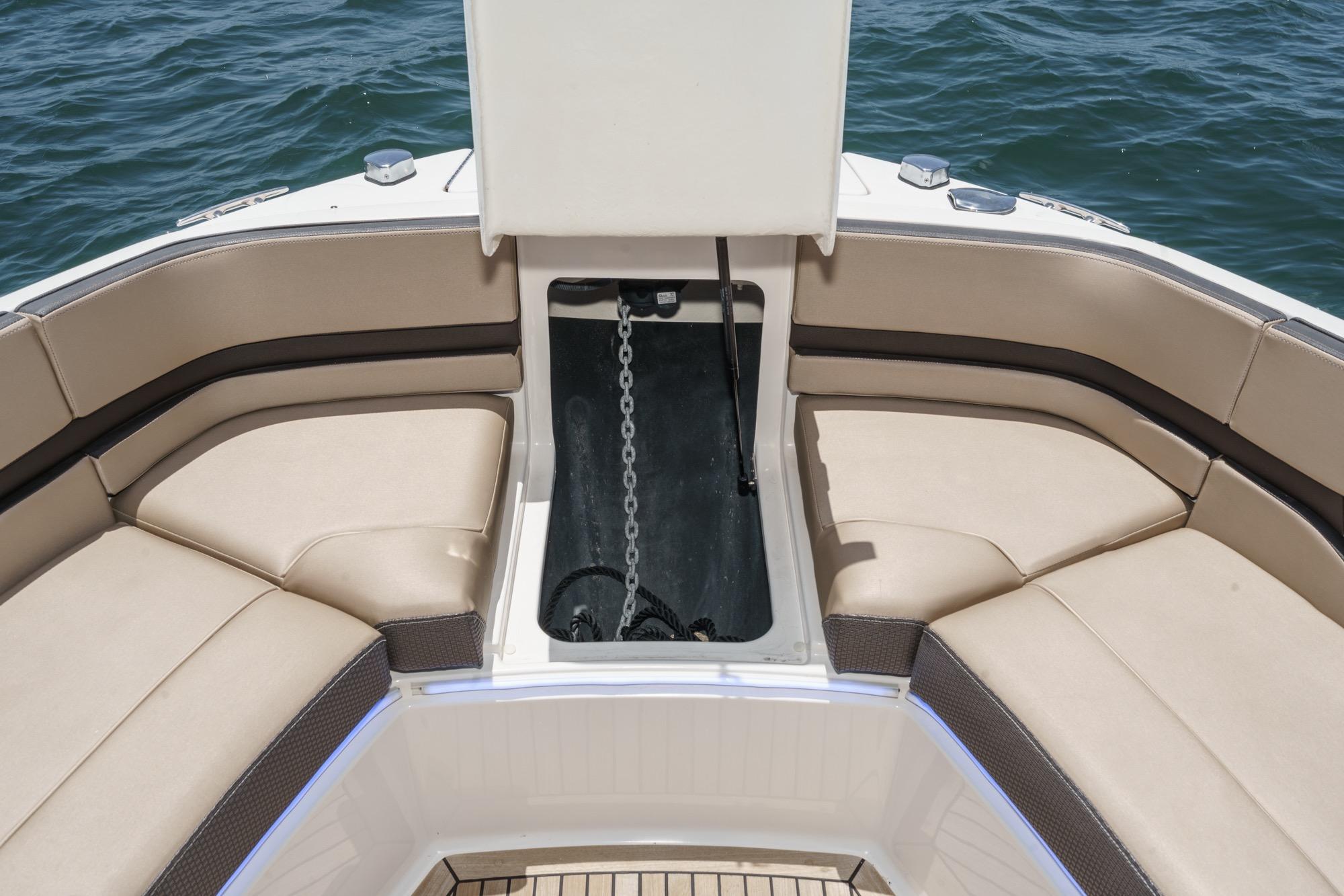 2018 Sea Ray SLX 310 boat interior with open anchor compartment and cushioned seating.