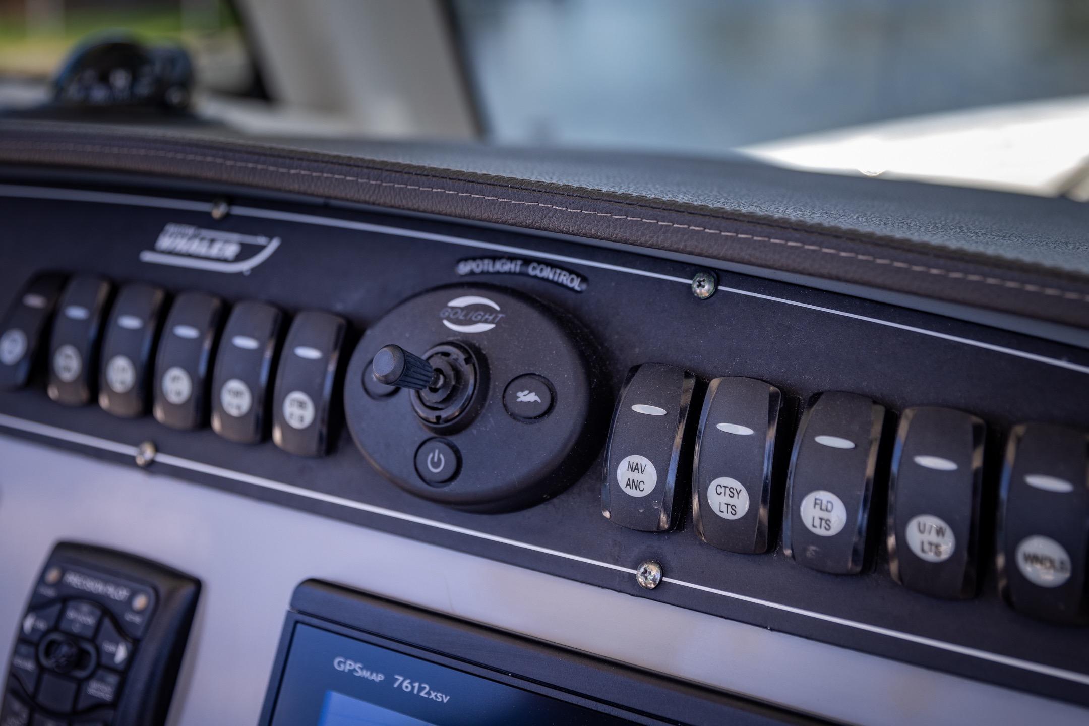 Control panel of a 2016 Boston Whaler 280 Outrage boat with switches and joystick.